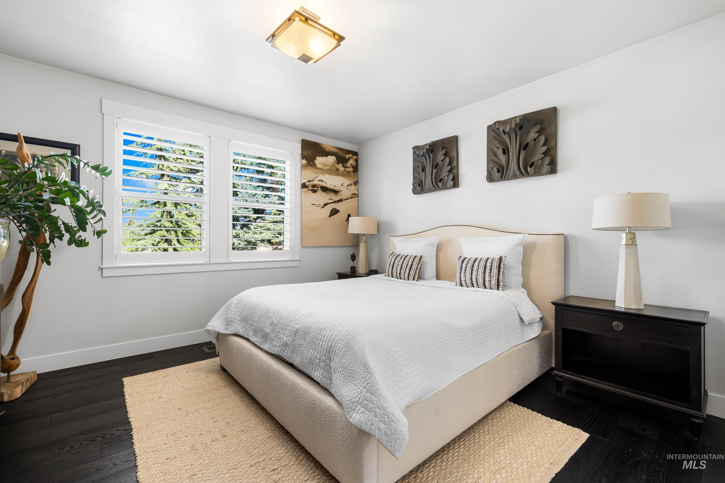Bedroom featuring baseboards and dark wood-style flooring