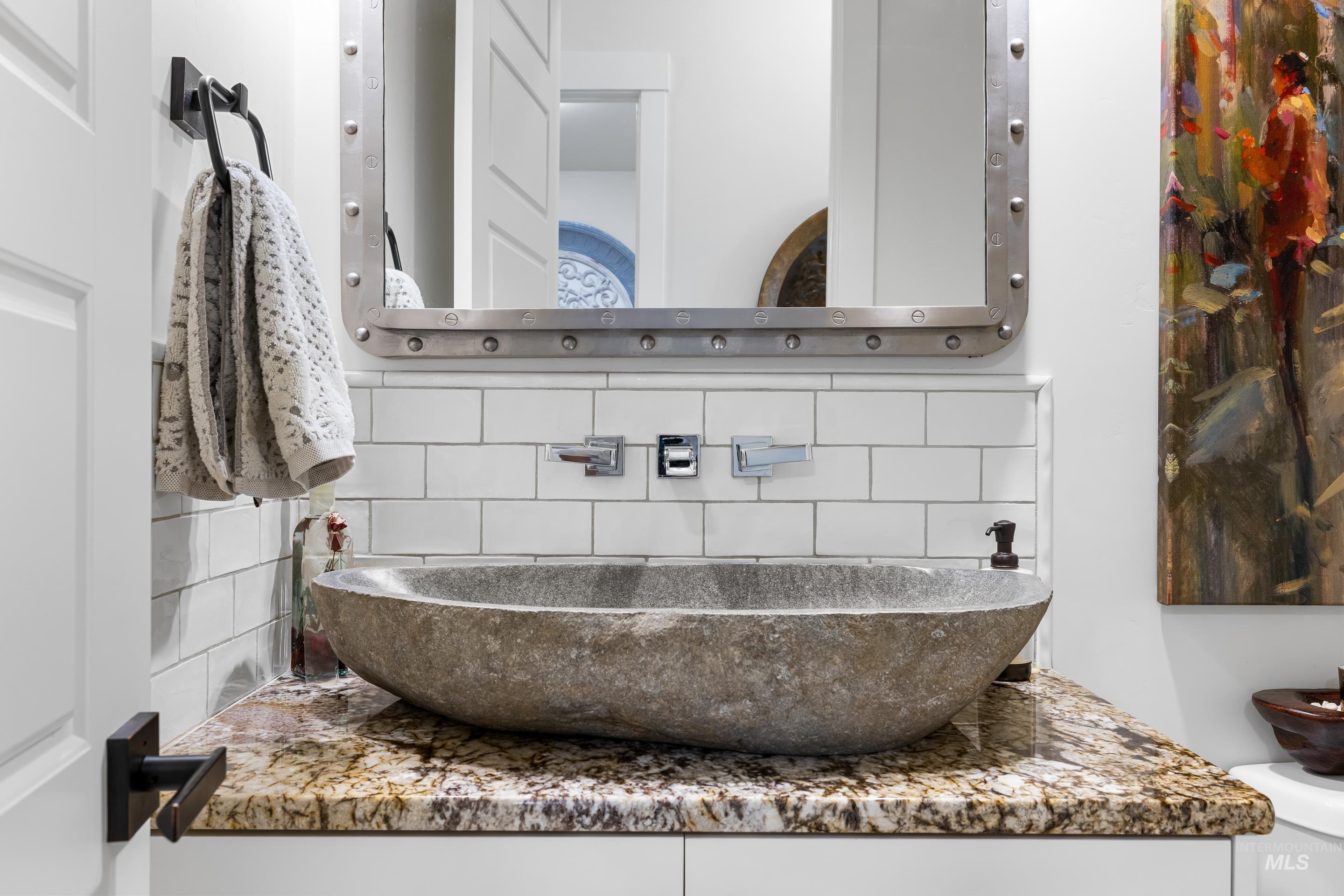 Bathroom featuring decorative backsplash and vanity