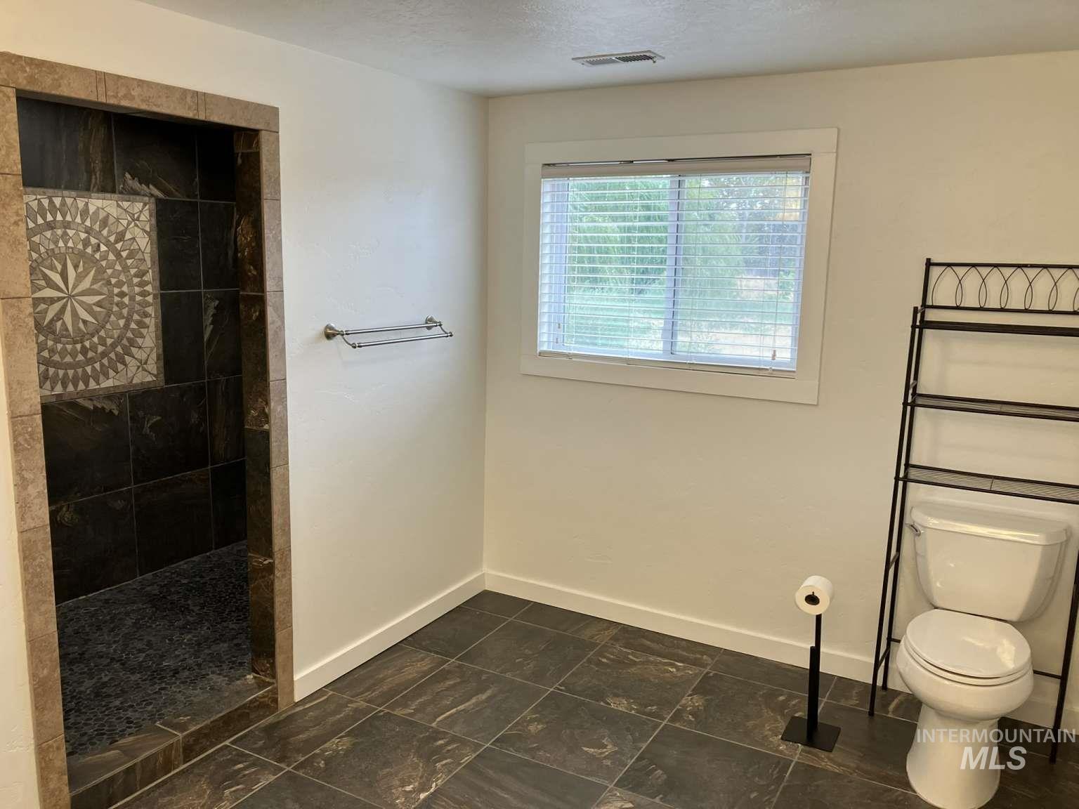 Bathroom featuring walk in shower and a textured ceiling