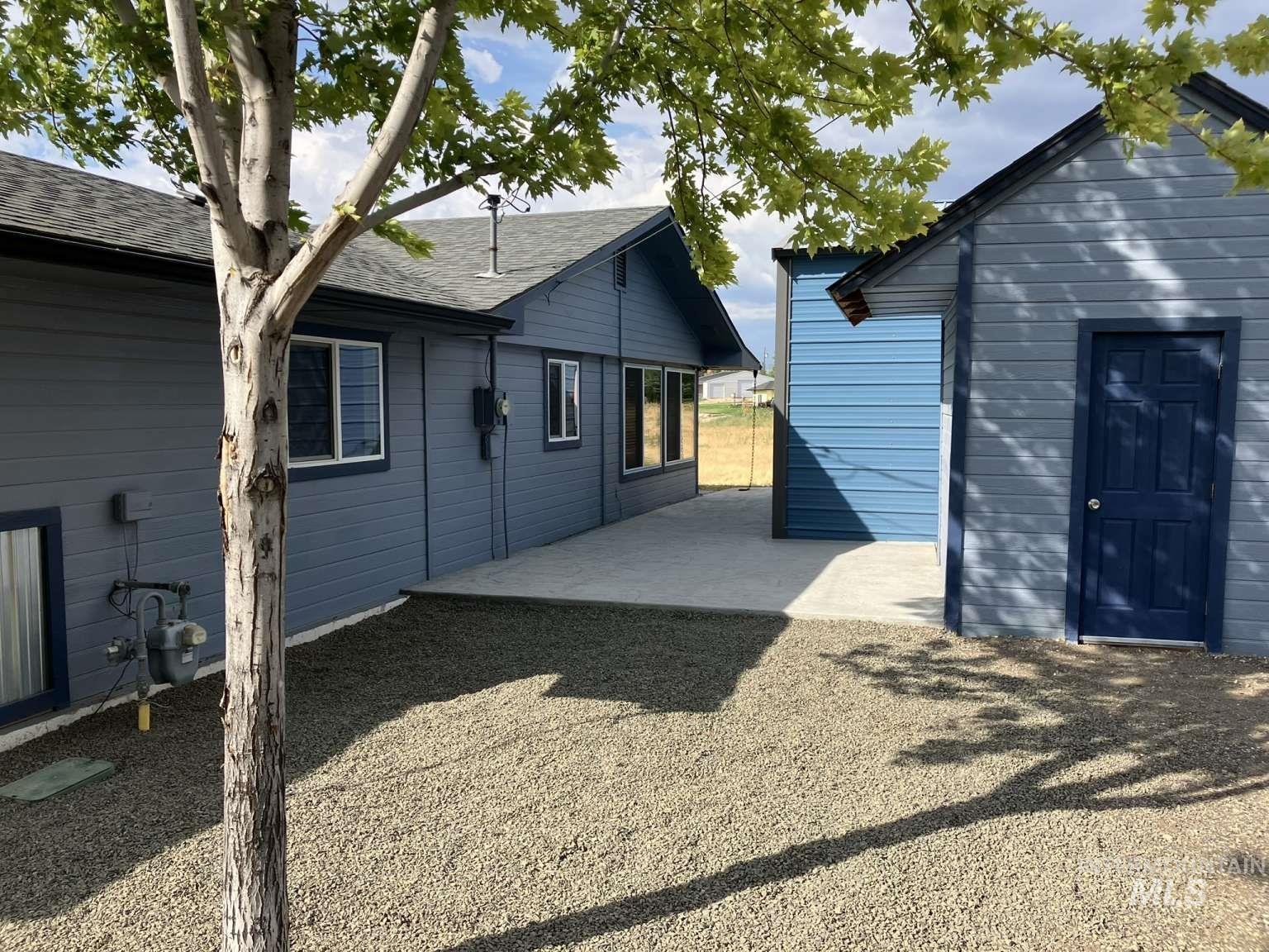 Back of property featuring a patio and roof with shingles