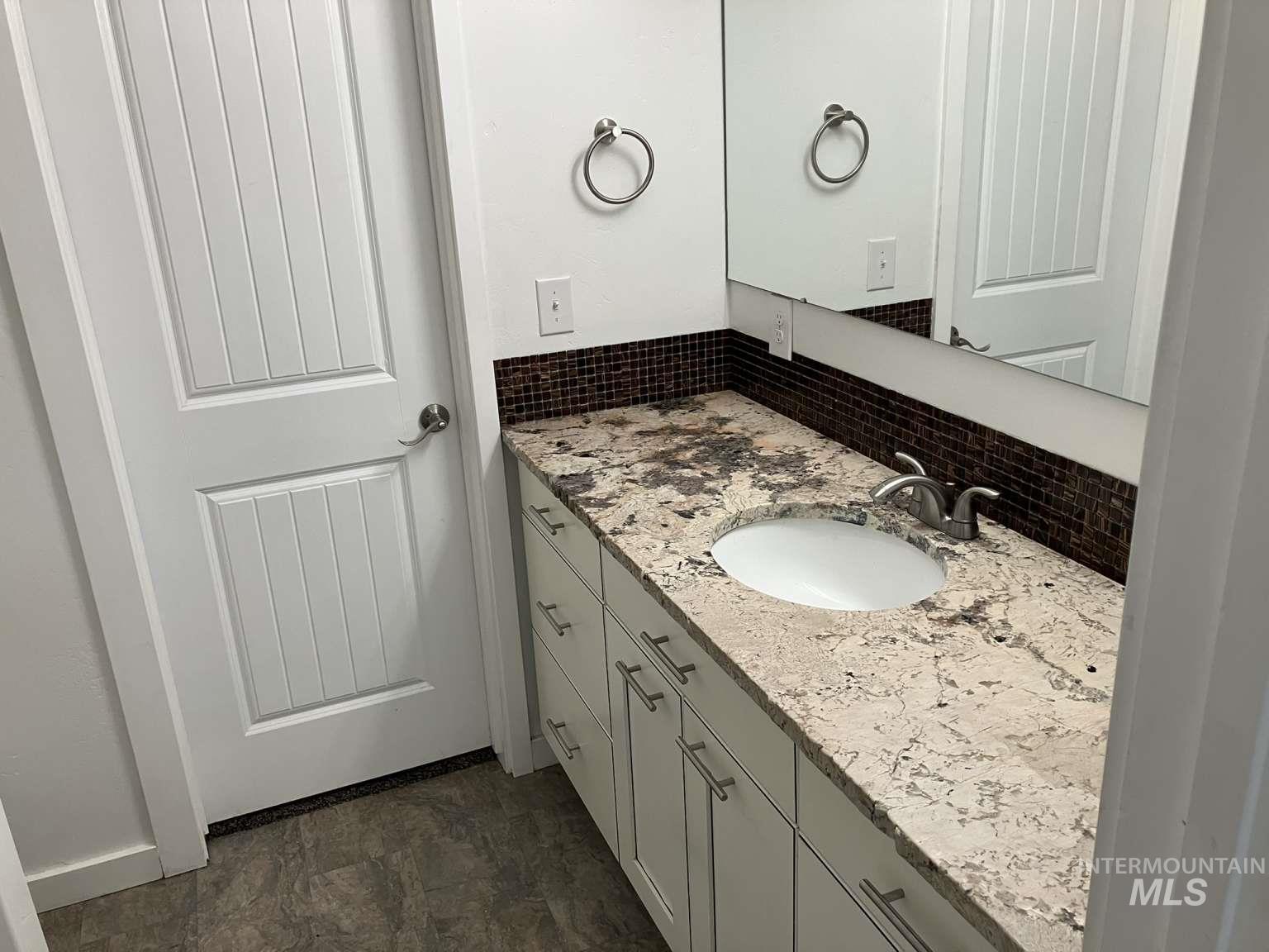 Bathroom featuring decorative backsplash and vanity
