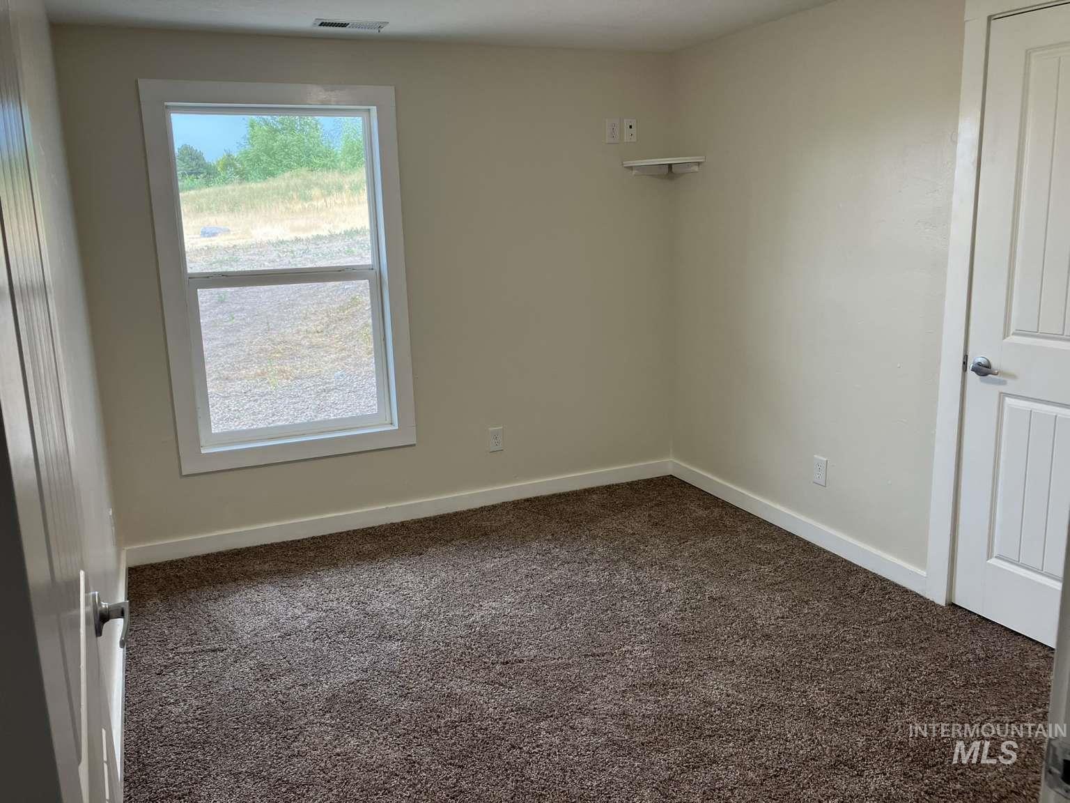Unfurnished bedroom with dark carpet