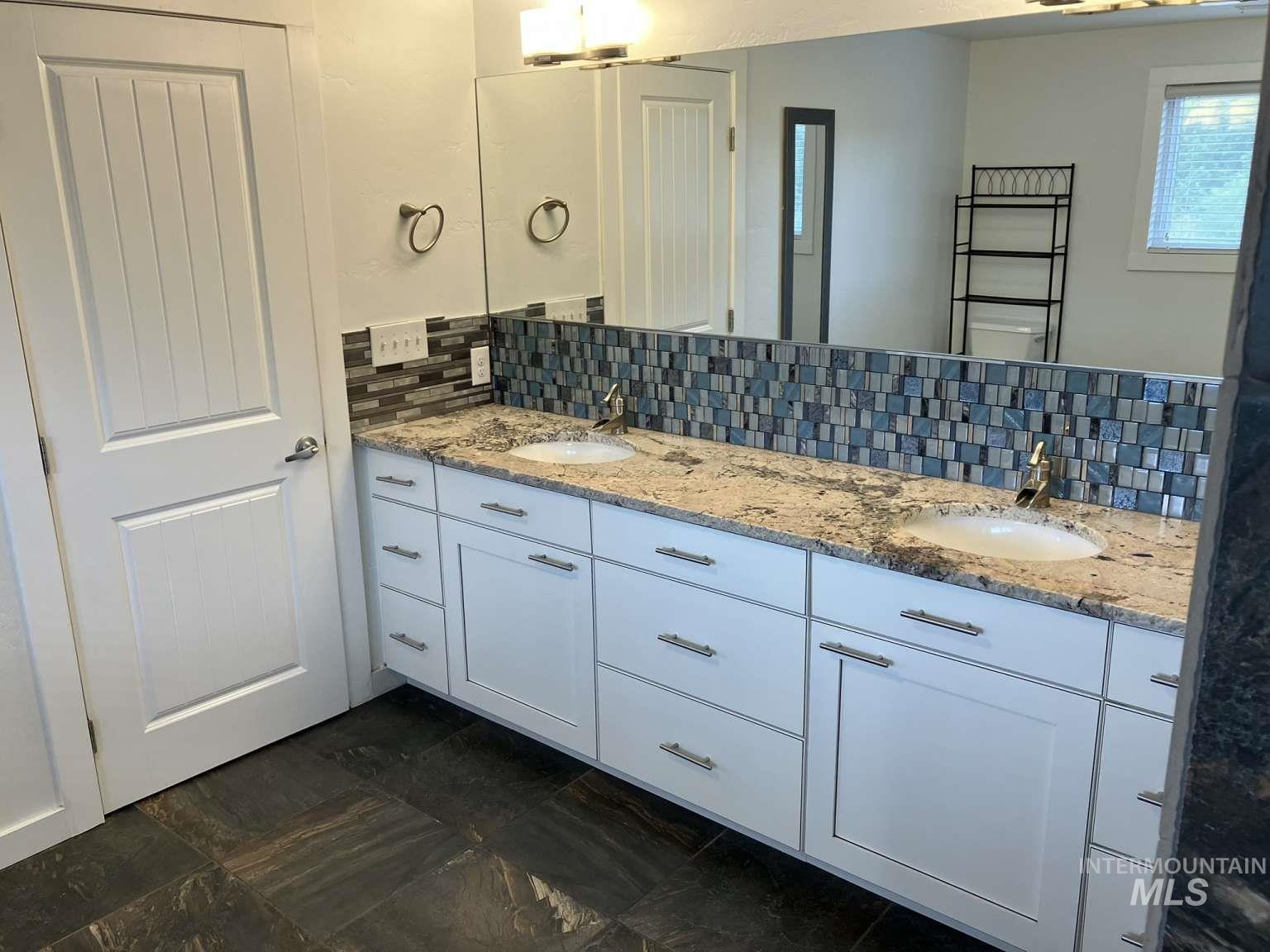 Full bathroom with backsplash and double vanity