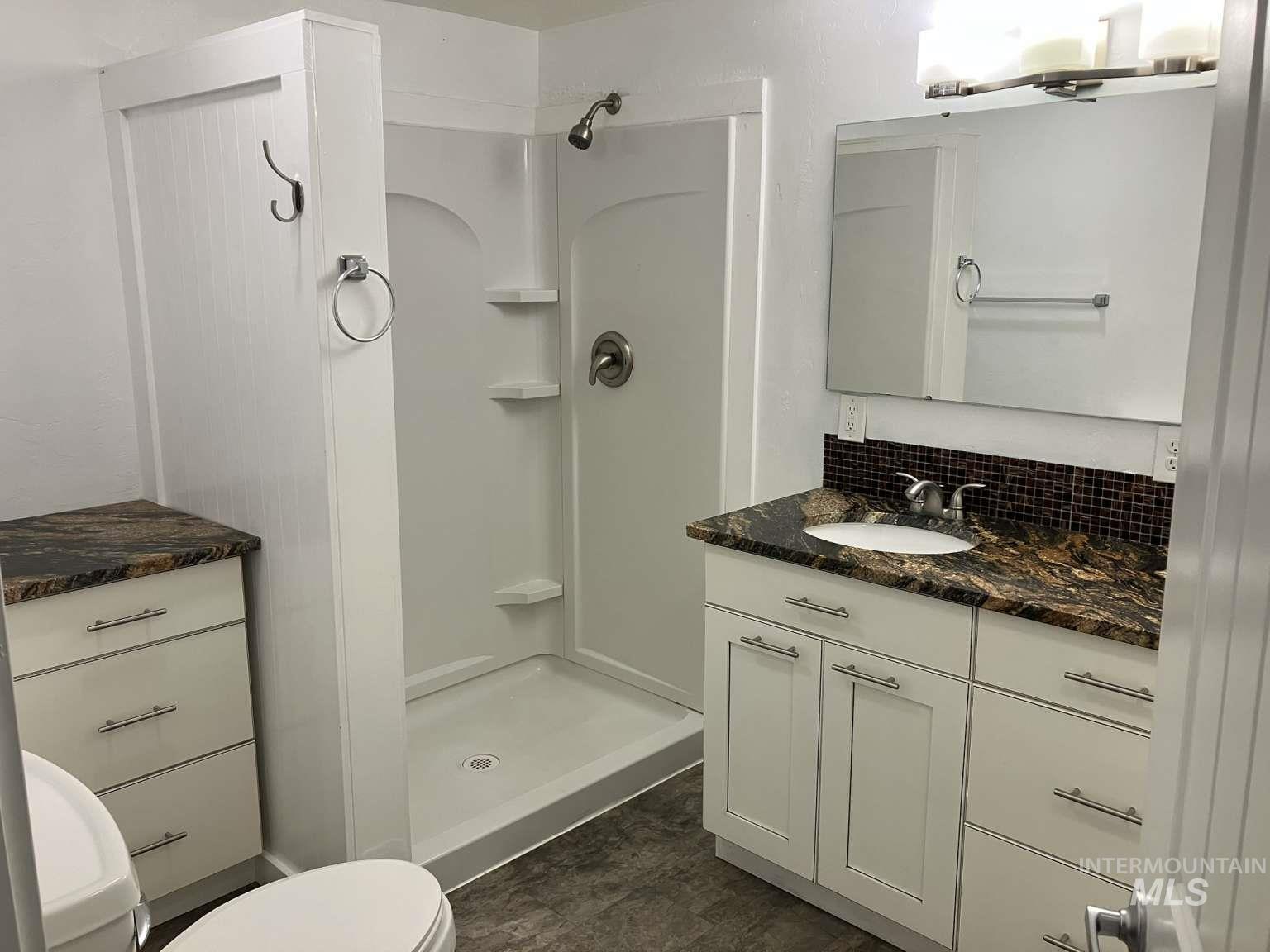 Full bath featuring a shower stall and vanity