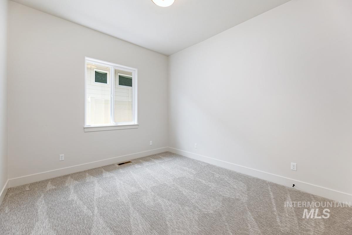 Unfurnished room with baseboards and light colored carpet