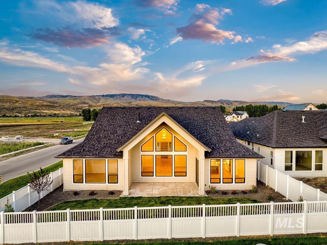 Back of property at dusk featuring a fenced front yard and a mountain view
