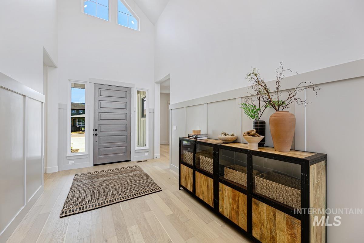Entrance foyer with light wood finished floors and a high ceiling