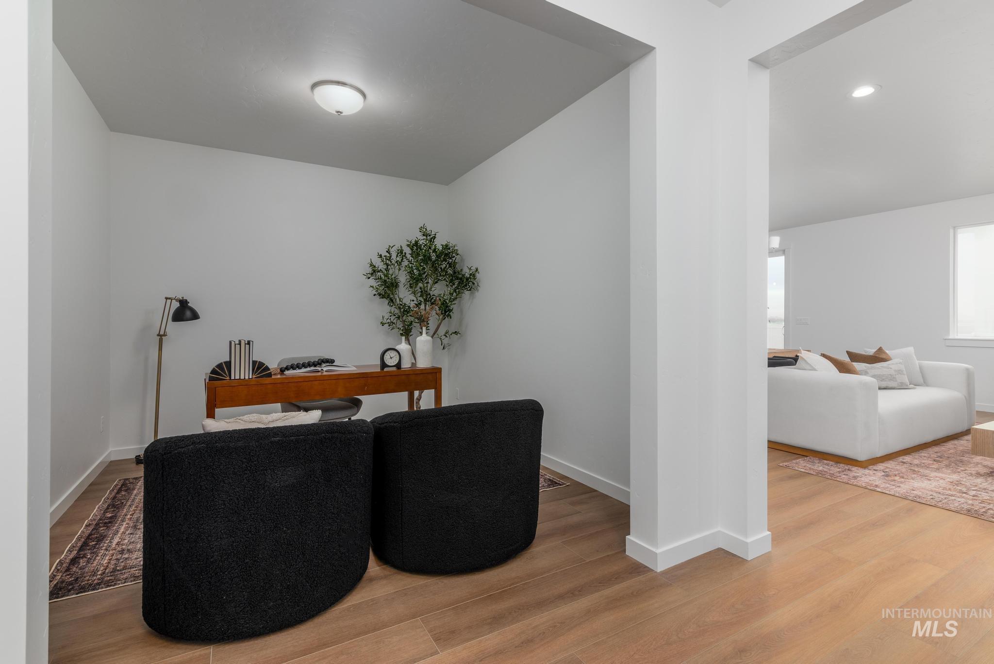 Living area with light wood-type flooring, an office area, and recessed lighting