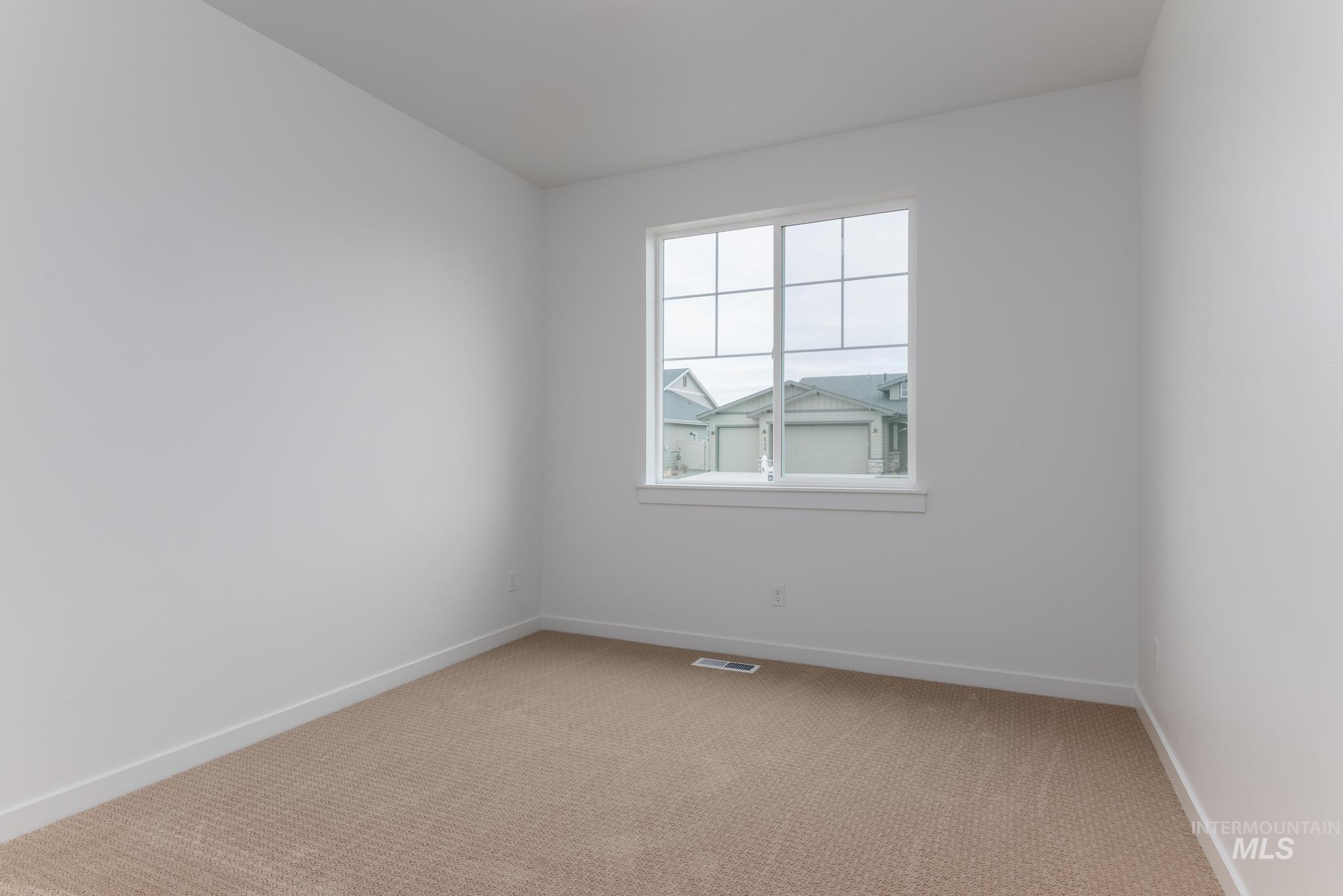 Spare room with light colored carpet and baseboards