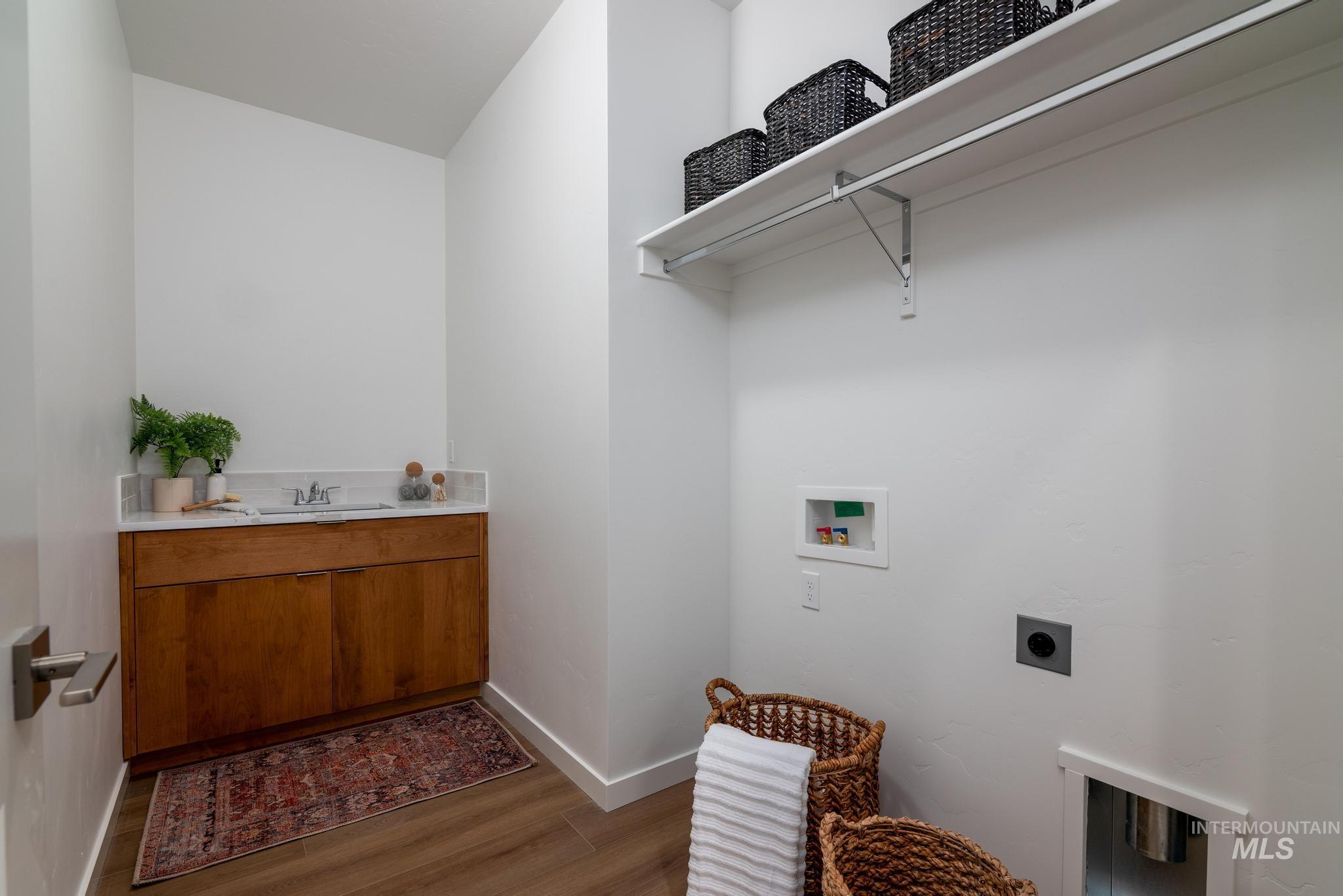Laundry area with dark wood finished floors, hookup for a washing machine, and electric dryer hookup