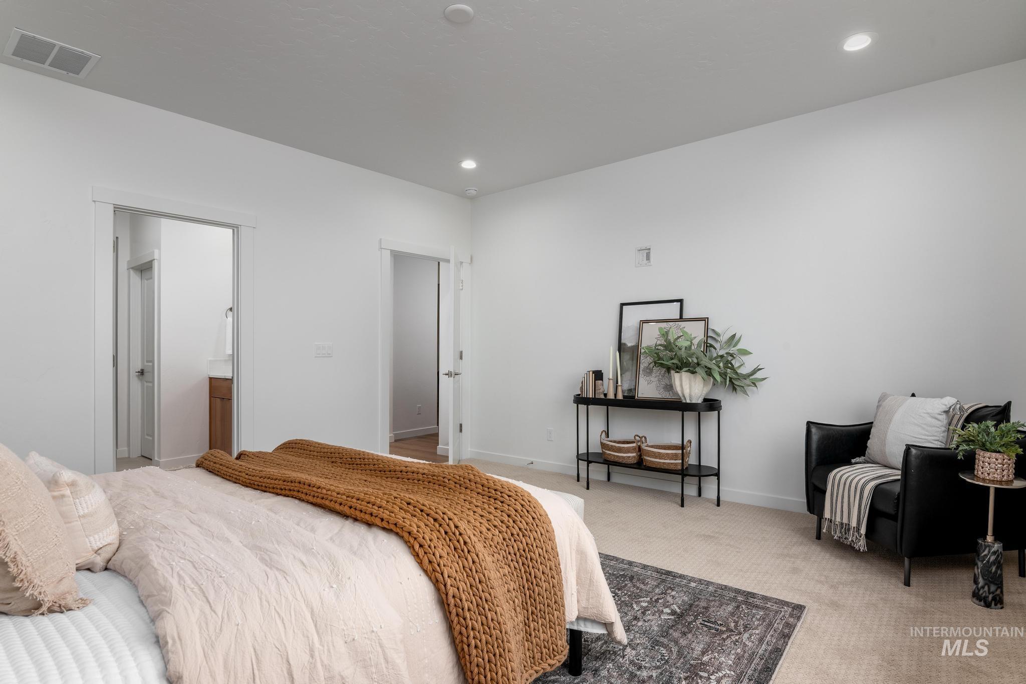 Carpeted bedroom with recessed lighting and connected bathroom