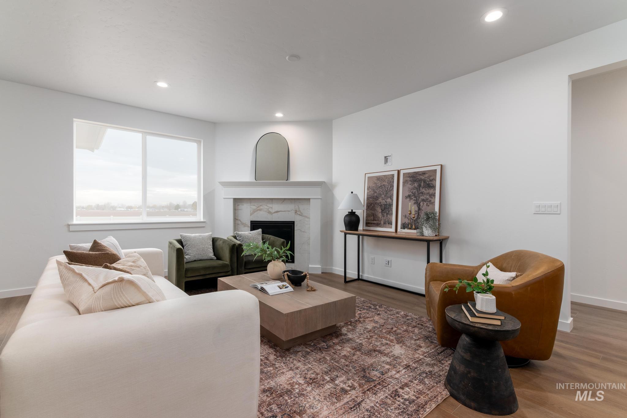 Living room featuring wood finished floors, a premium fireplace, and recessed lighting