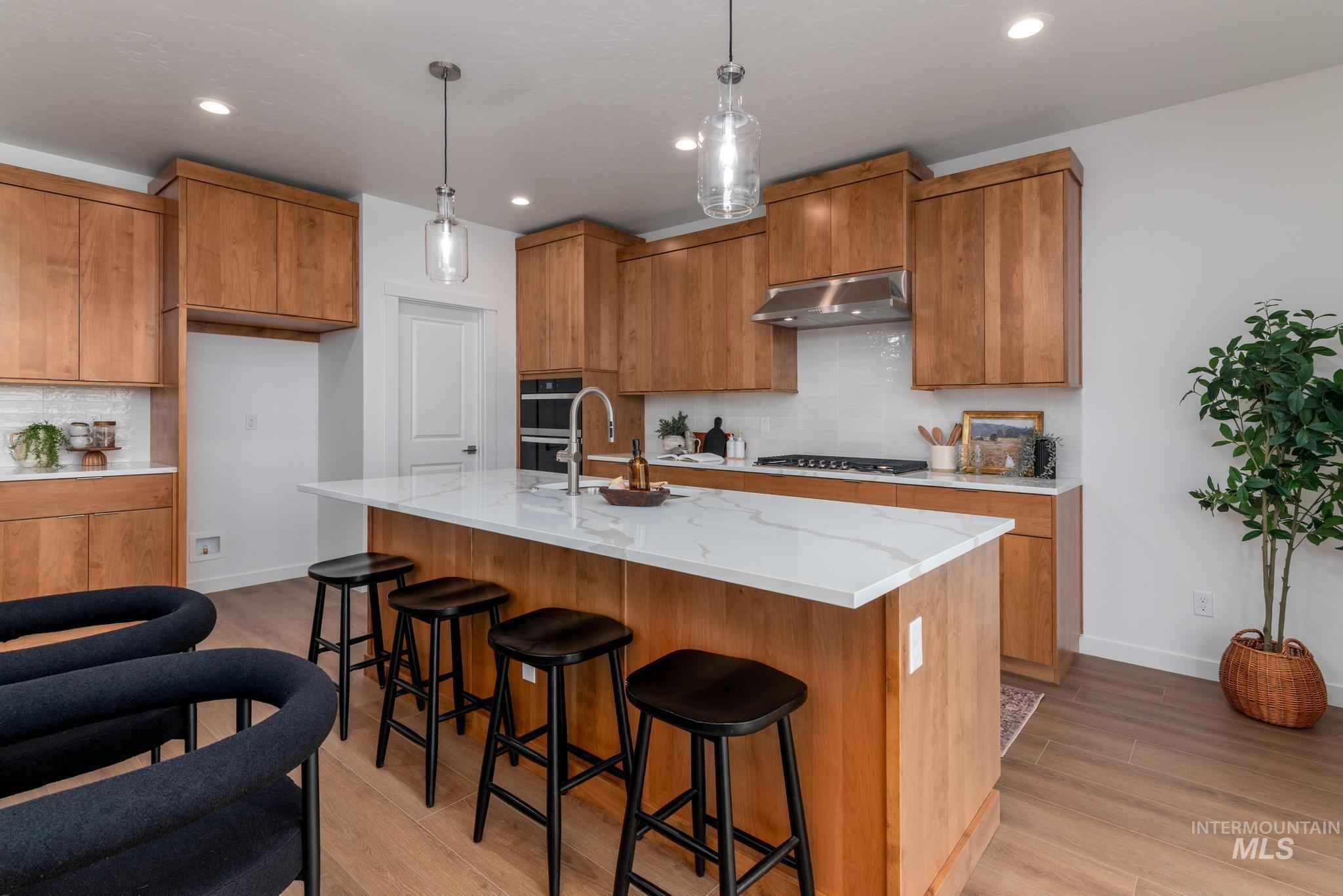 Kitchen featuring tasteful backsplash, brown cabinets, light wood-style floors, and recessed lighting
