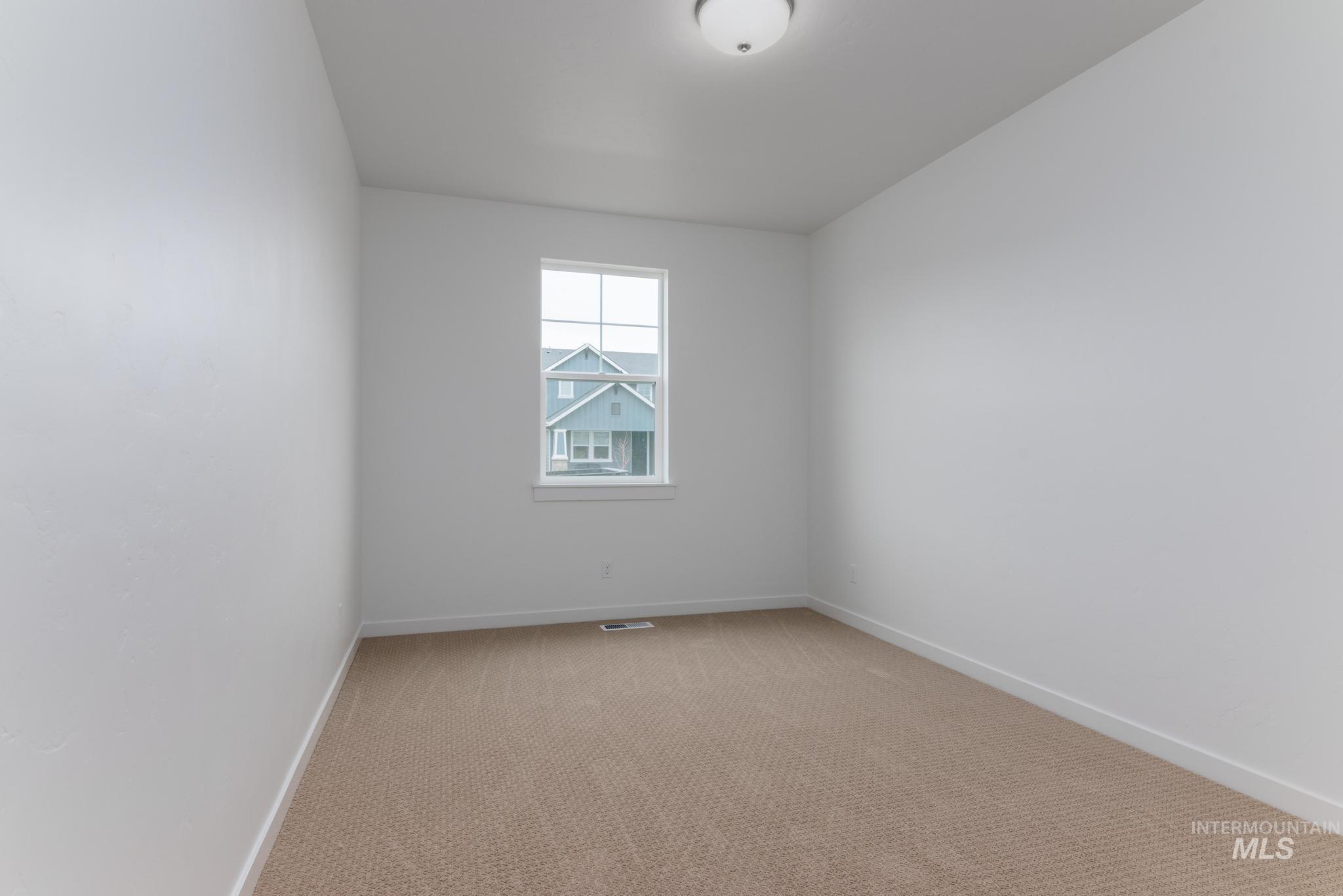Carpeted empty room with baseboards