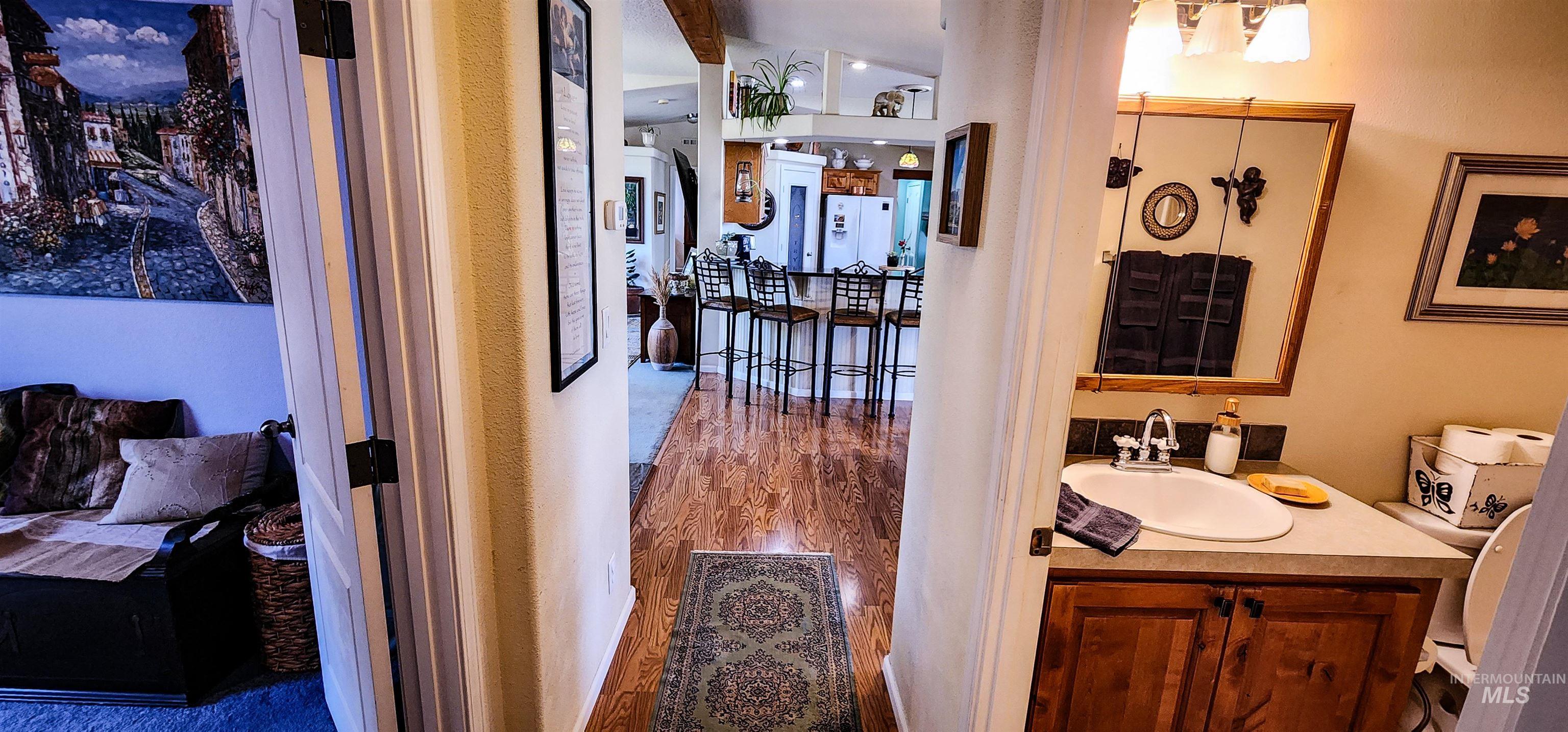 Bathroom featuring vanity, dark wood-type flooring, and vaulted ceiling