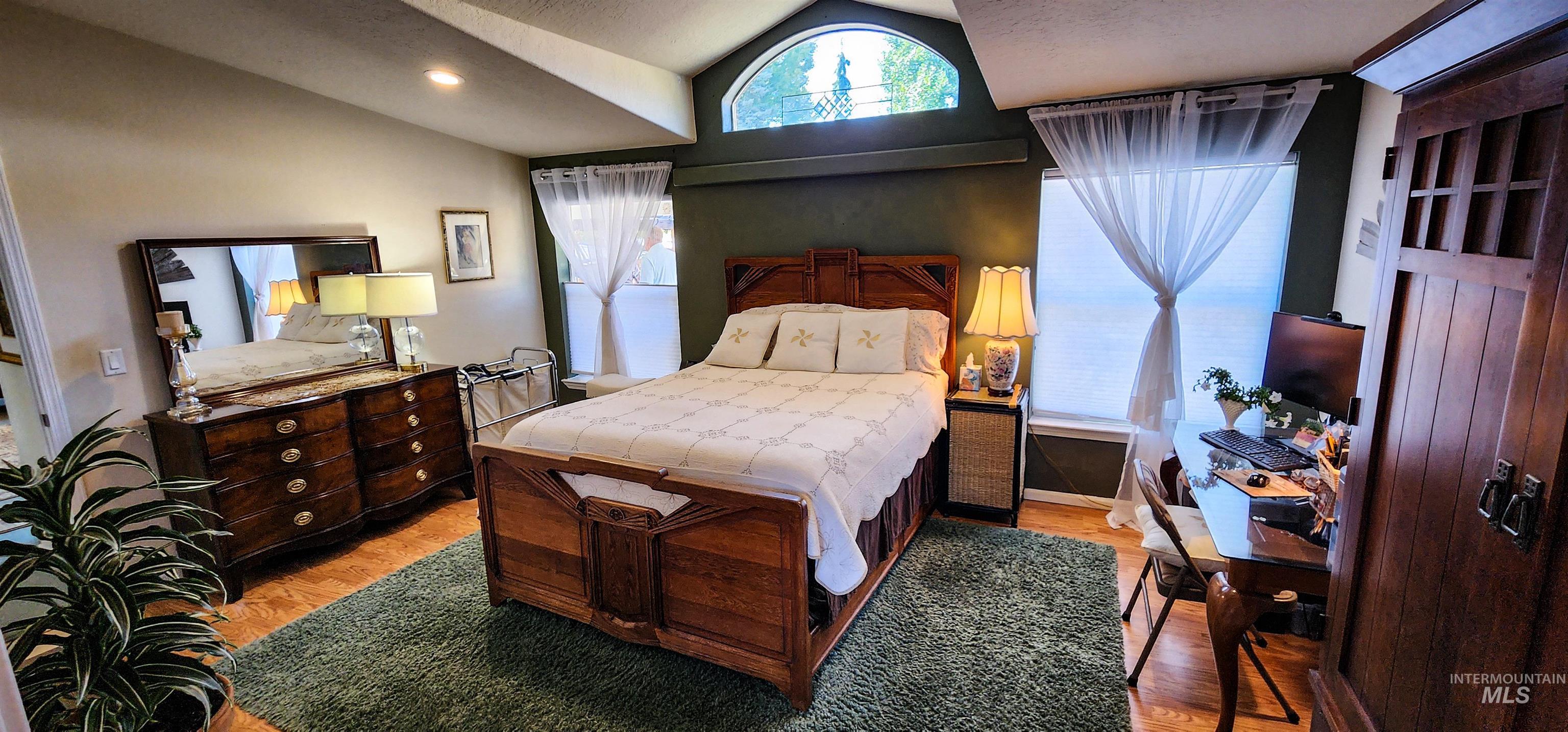 Bedroom featuring lofted ceiling, wood finished floors, a textured ceiling, and recessed lighting