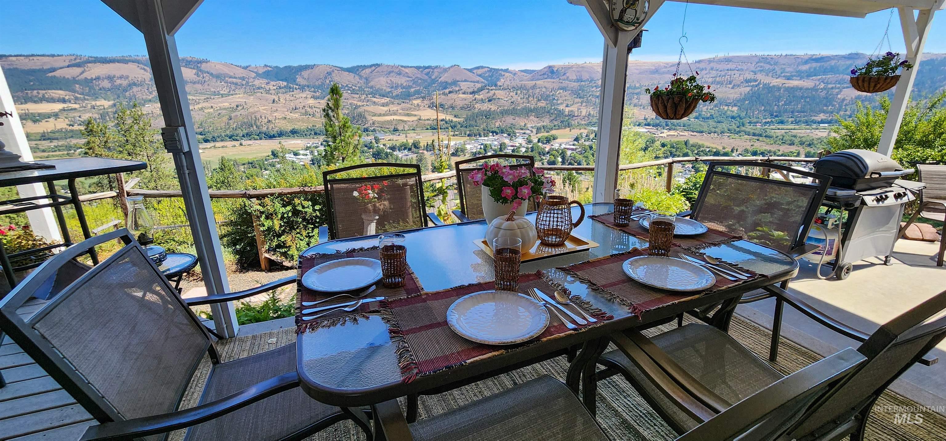 Balcony featuring area for grilling, outdoor dining area, and a mountain view