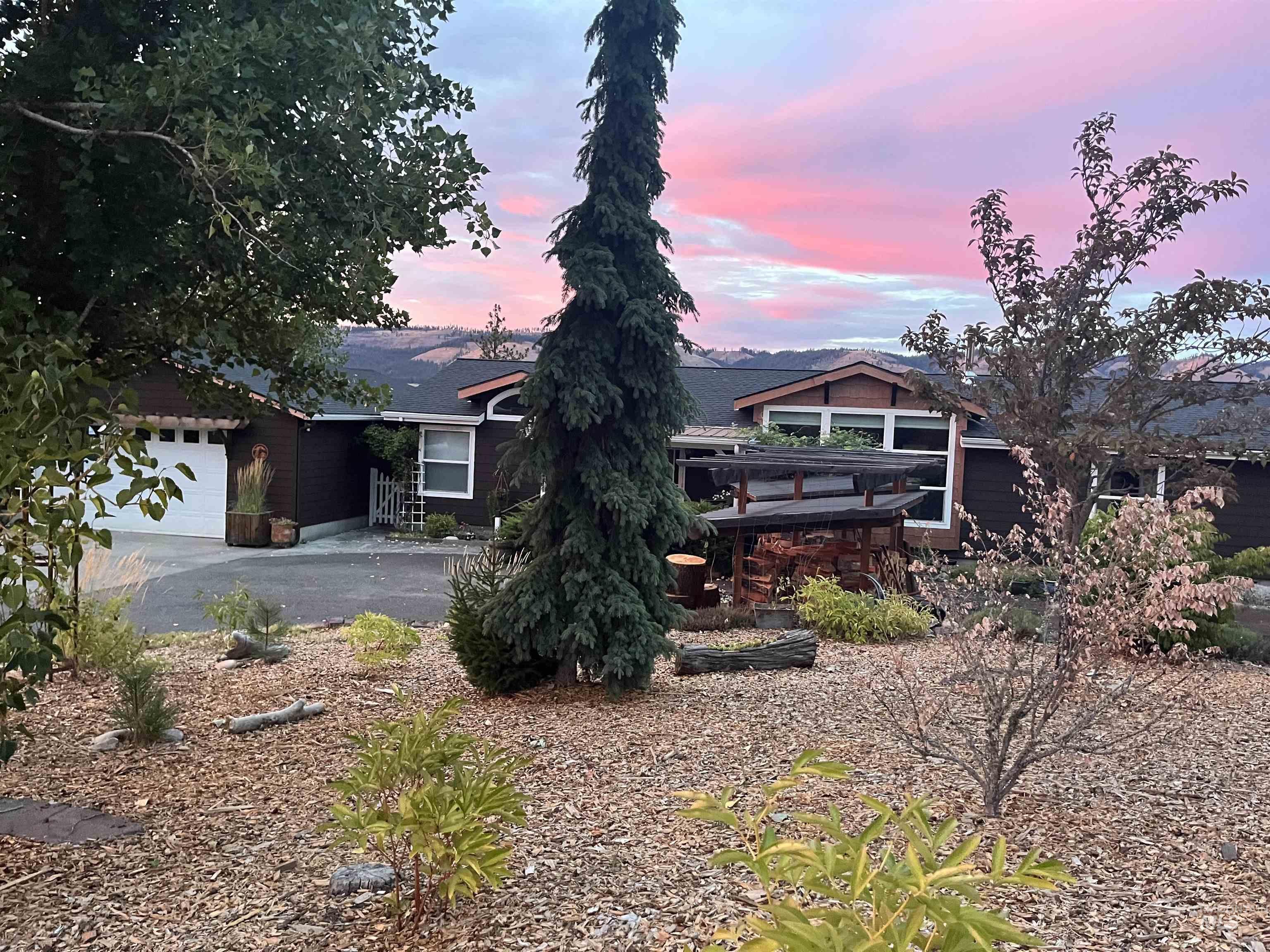 View of front of property with asphalt driveway and a garage