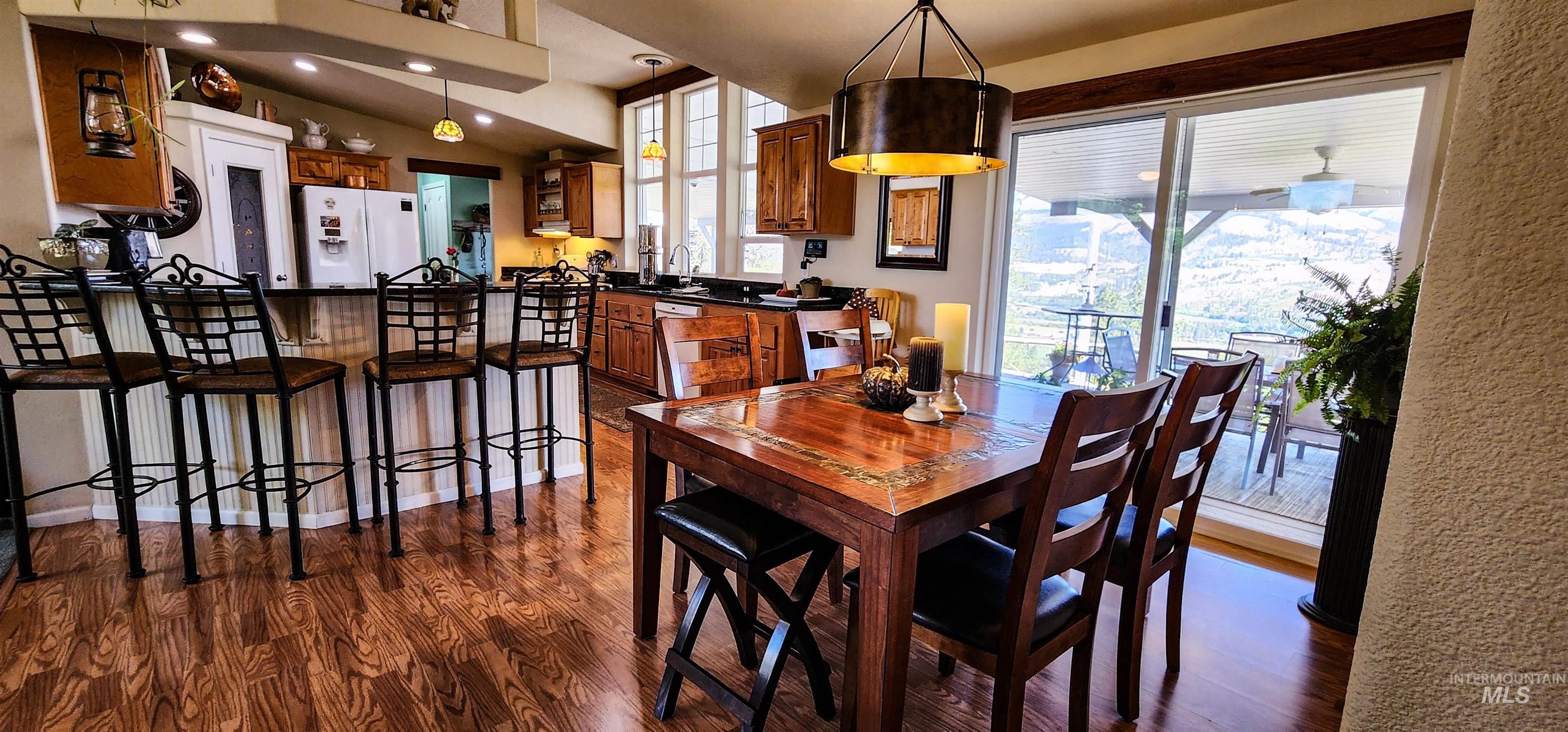Dining area with dark wood finished floors and recessed lighting