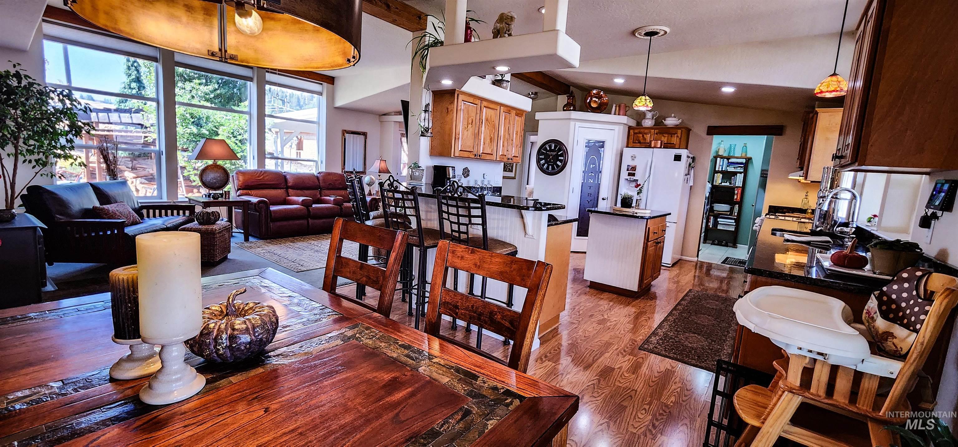 Dining area featuring dark wood-style floors and a towering ceiling