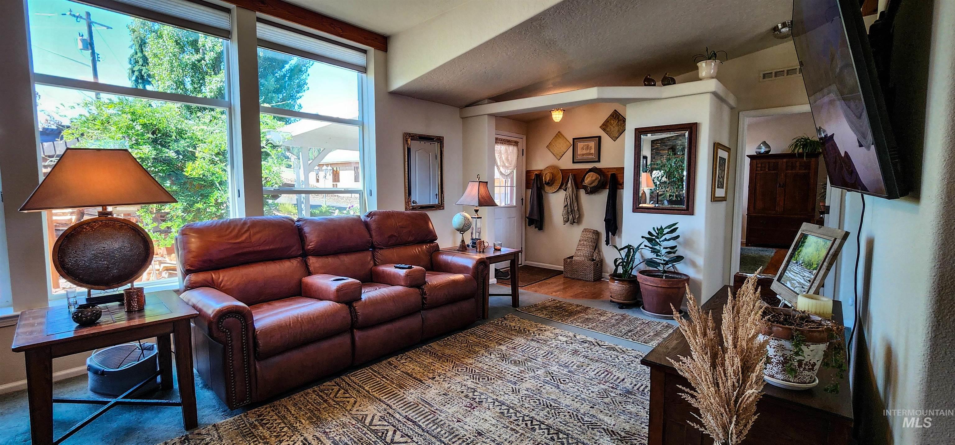 Living area with vaulted ceiling and wood finished floors