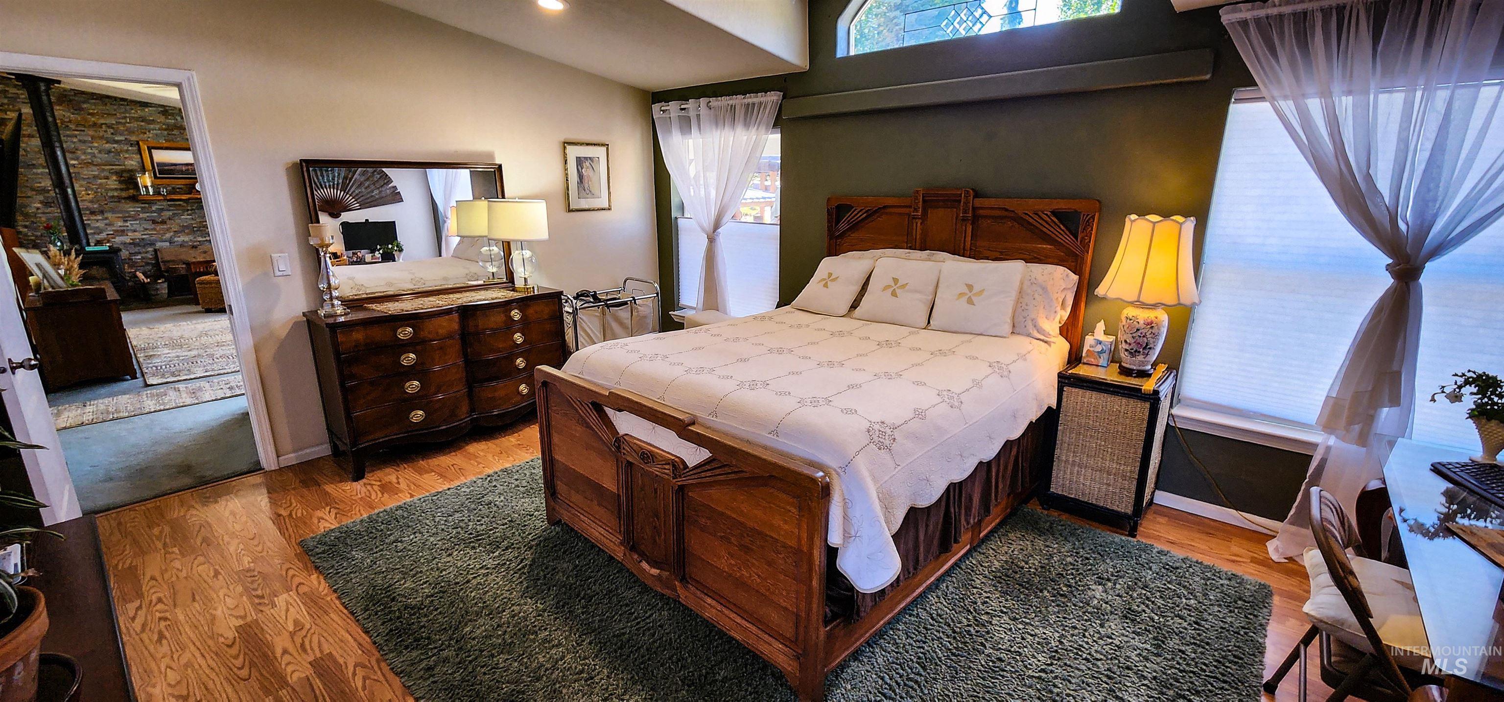 Bedroom featuring light wood-style flooring and vaulted ceiling