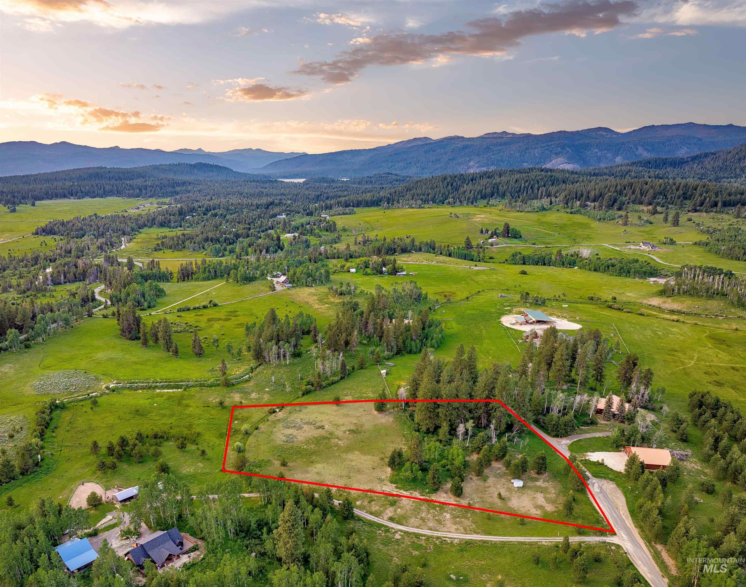 Aerial view at dusk of property boundaries highlighted, a mountain view, a rural view, and a view of trees