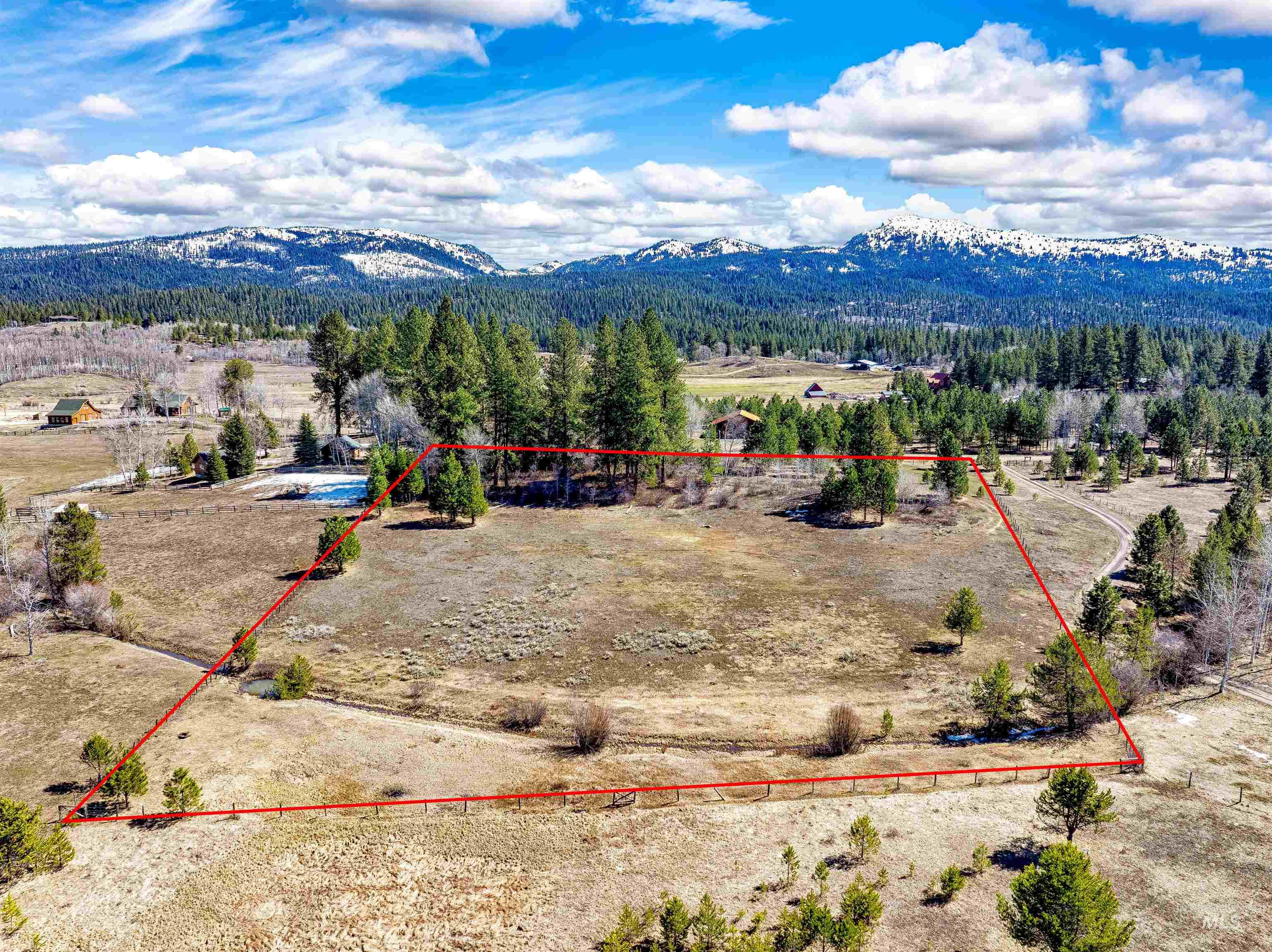 Aerial view of sparsely populated area featuring property boundaries highlighted and mountains