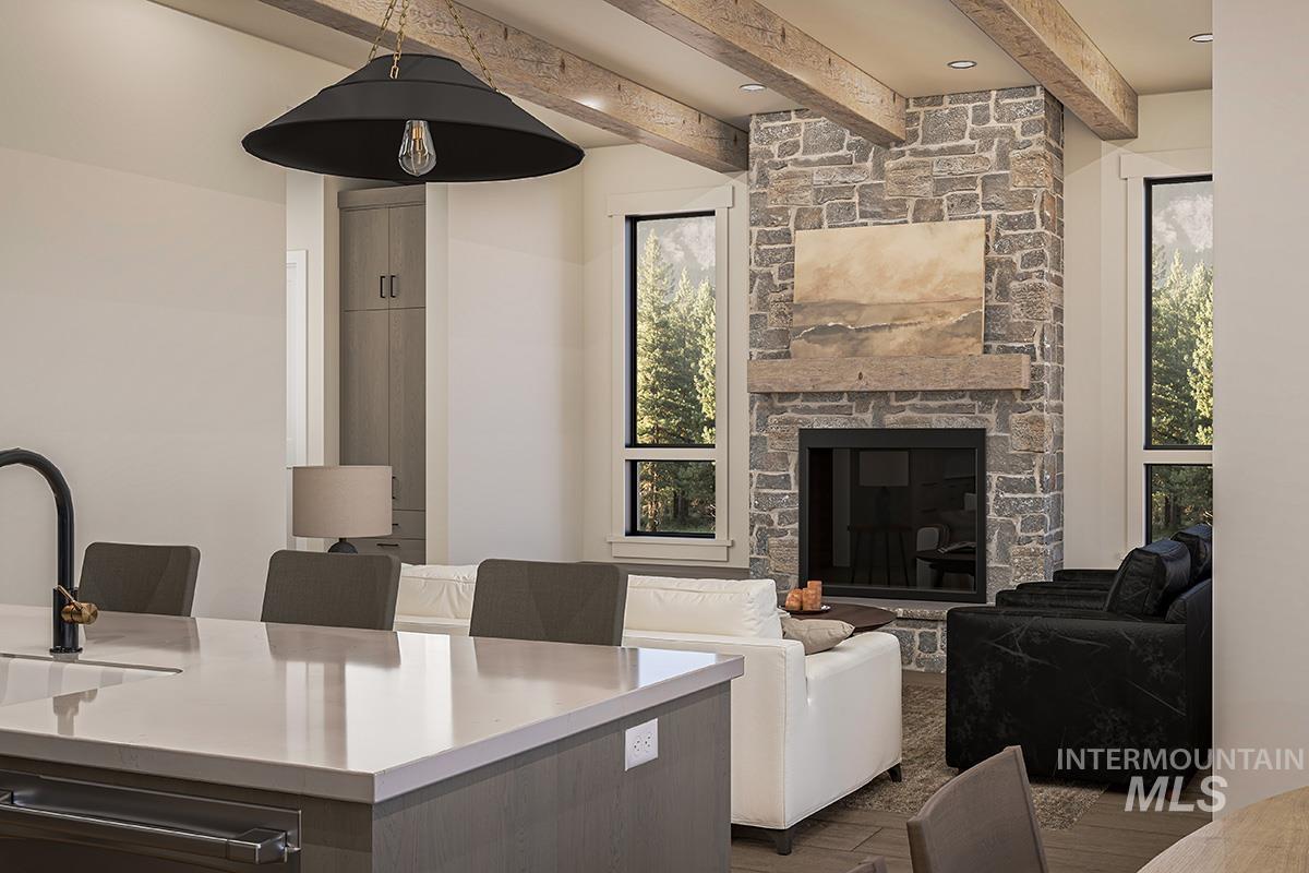 Living area featuring beam ceiling, a fireplace, and wood finished floors
