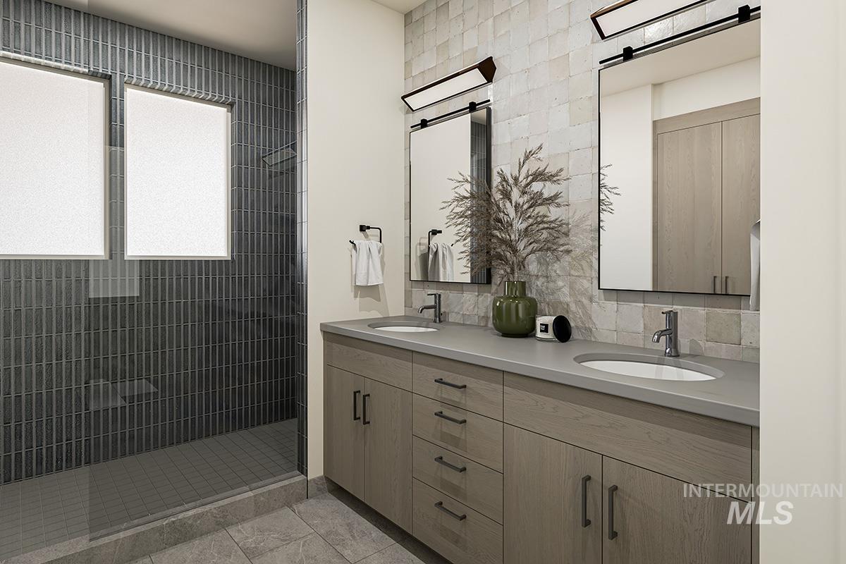 Bathroom featuring double vanity, a shower stall, and tasteful backsplash