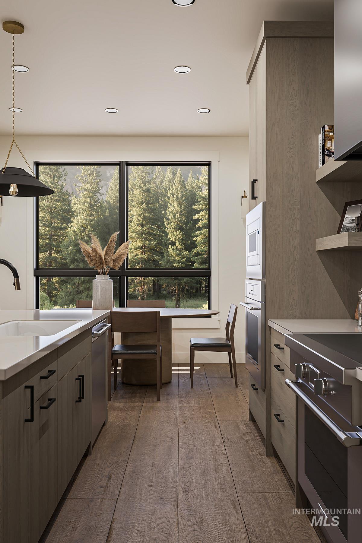 Kitchen featuring stainless steel appliances, modern cabinets, hanging light fixtures, dark wood-style flooring, and plenty of natural light