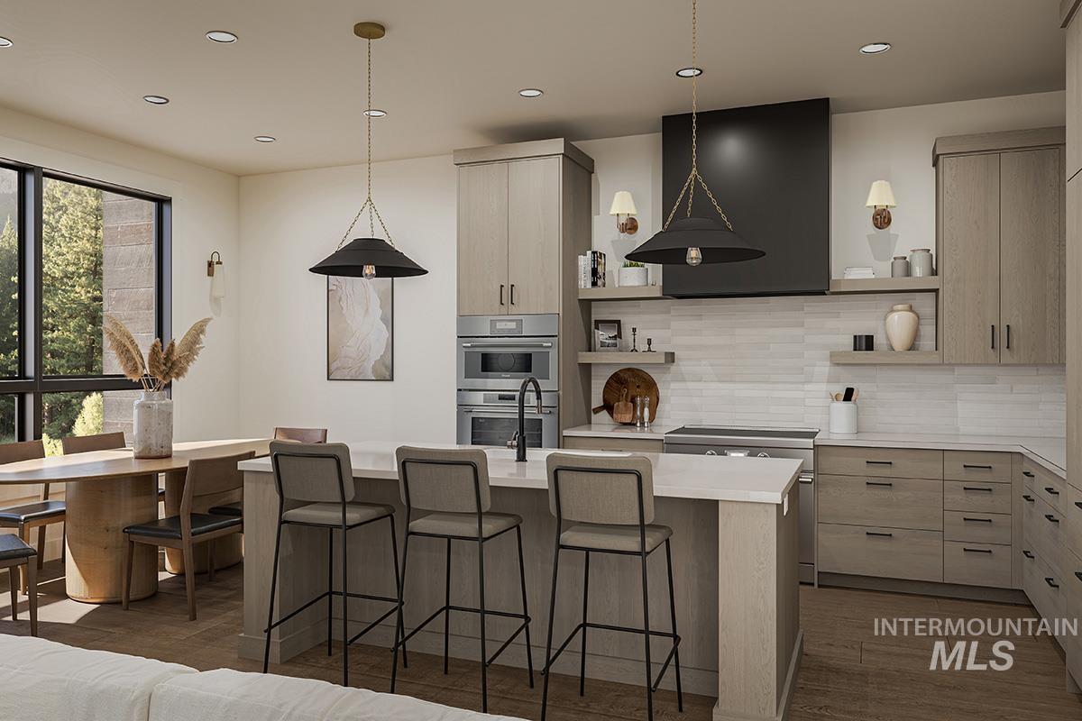 Kitchen featuring modern cabinets, light brown cabinetry, backsplash, decorative light fixtures, and recessed lighting