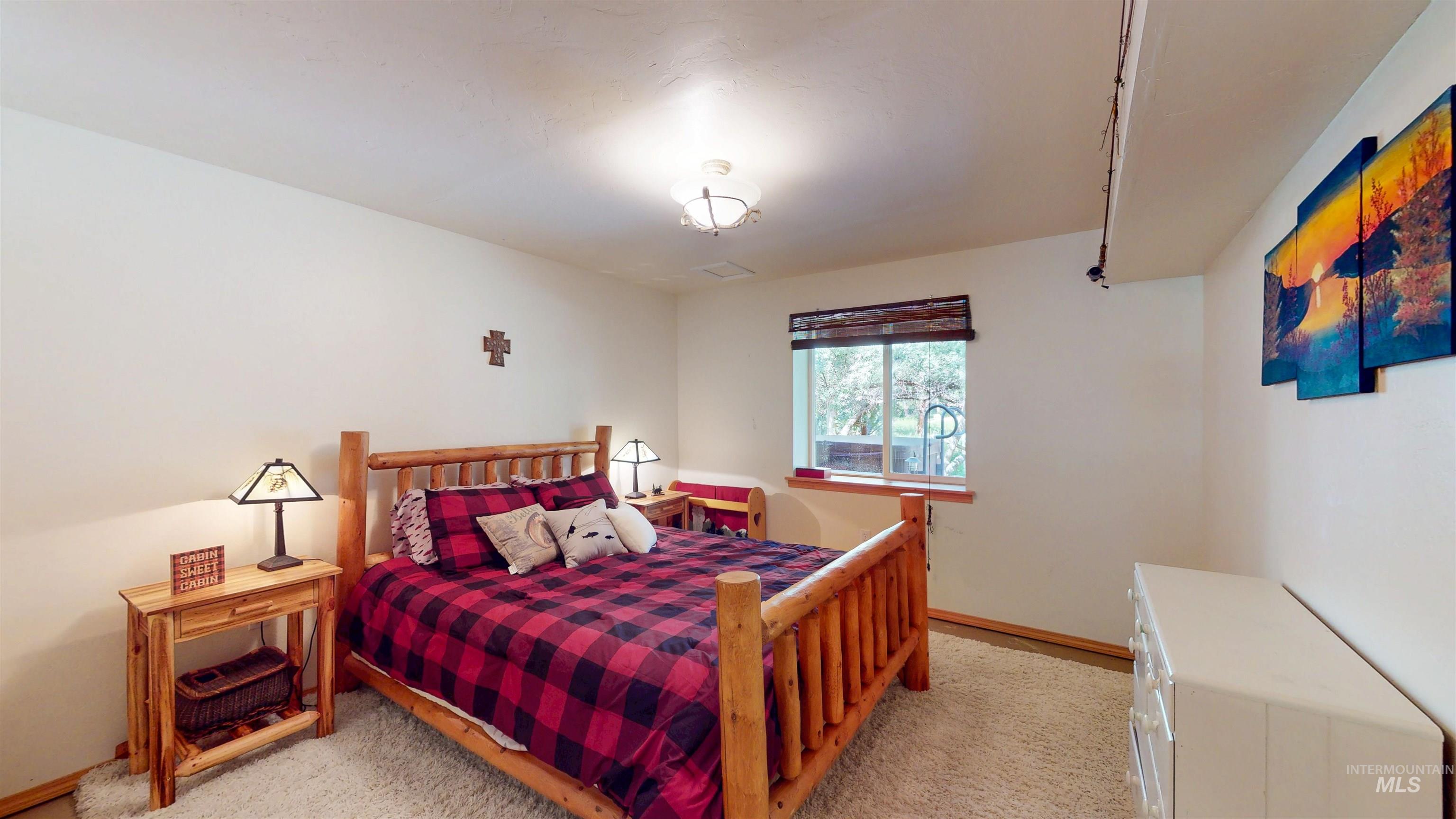 Bedroom featuring light carpet and baseboards