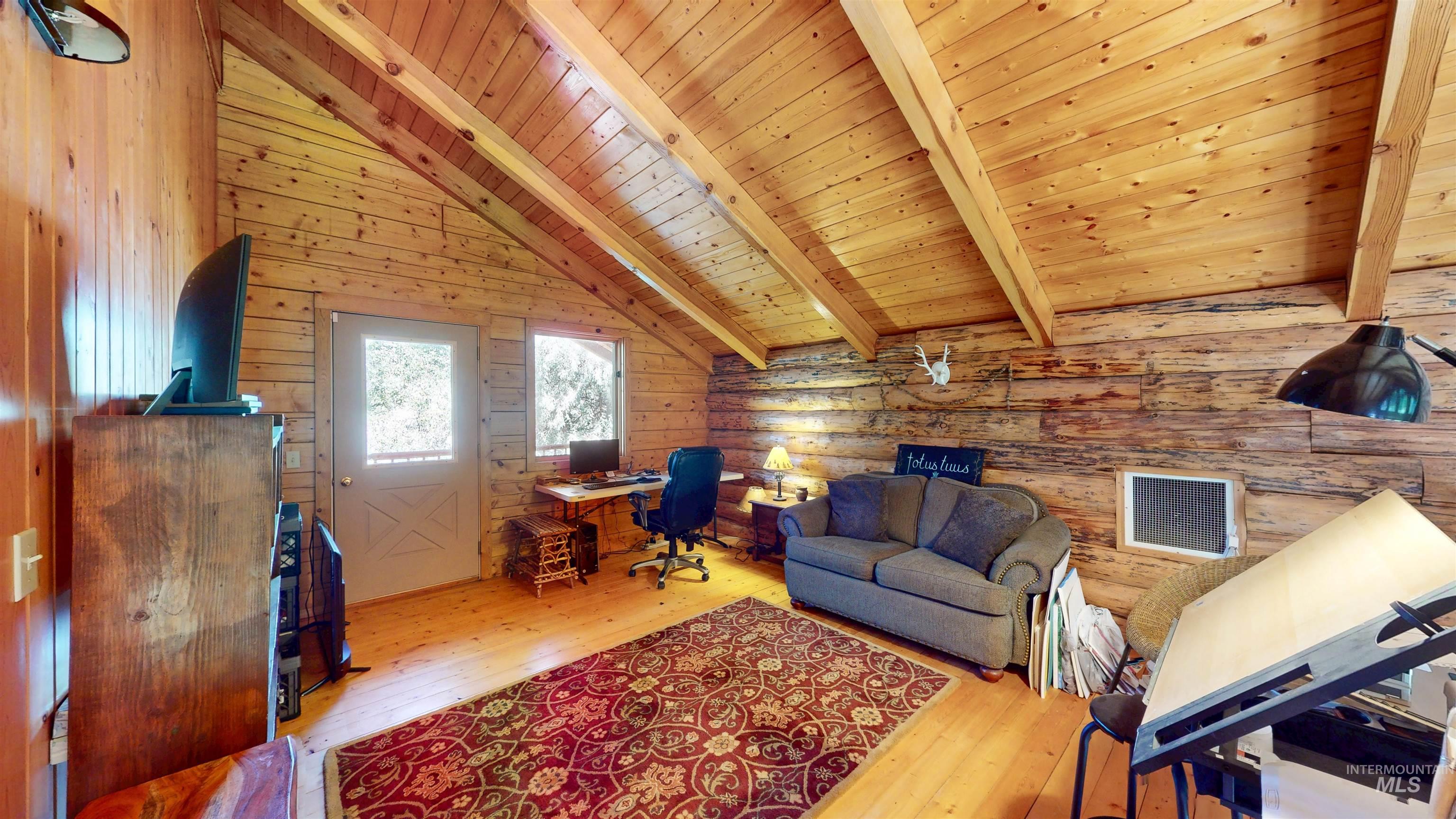 Office area featuring wooden ceiling, hardwood / wood-style flooring, and rustic walls