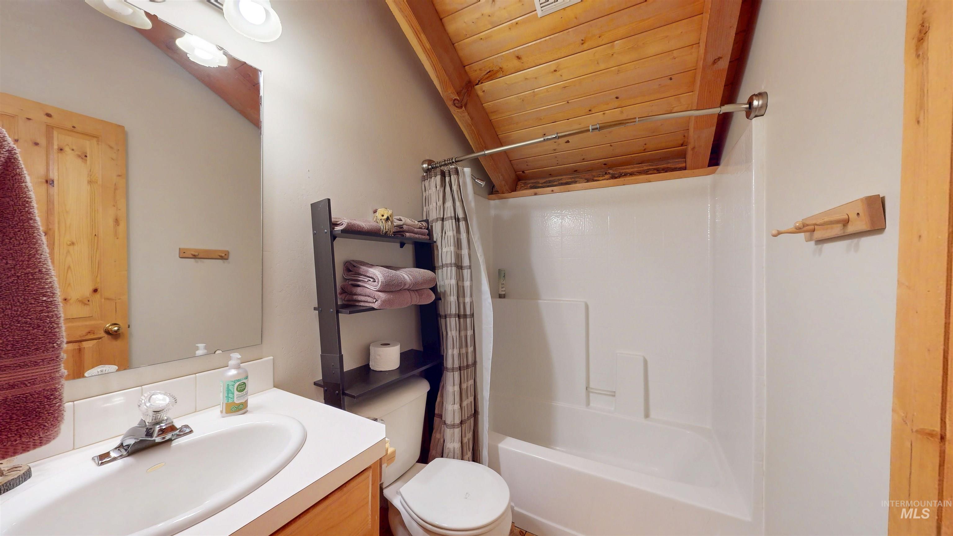 Bathroom with vanity, wooden ceiling, shower / bath combo with shower curtain, and lofted ceiling