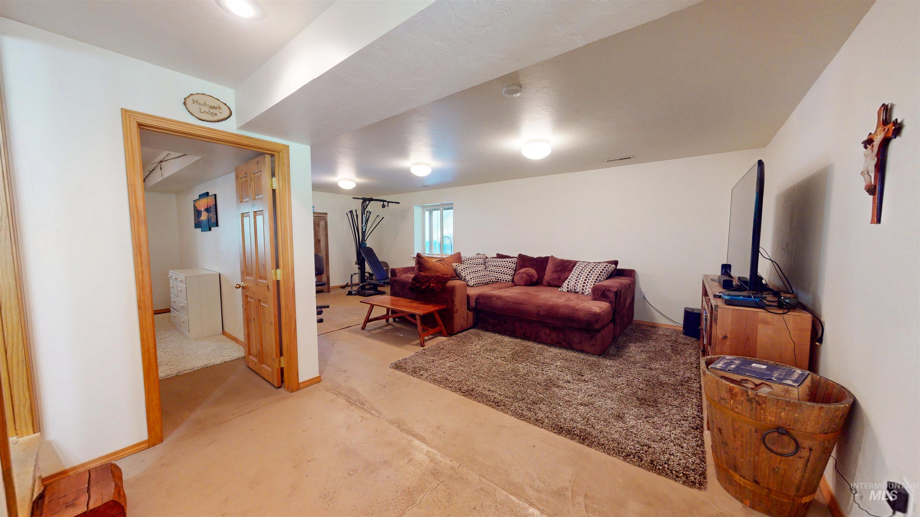 Living room featuring concrete flooring and baseboards