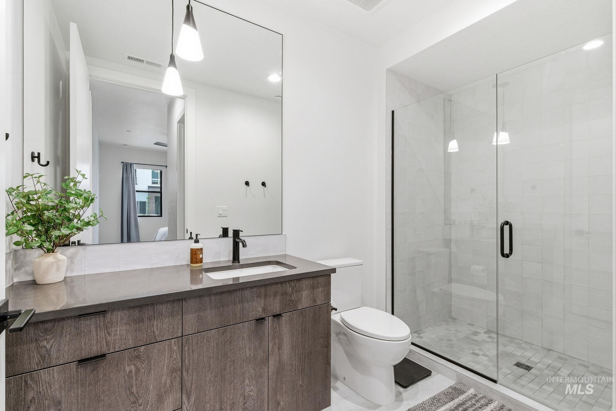 Full bathroom with vanity, a shower stall, and recessed lighting