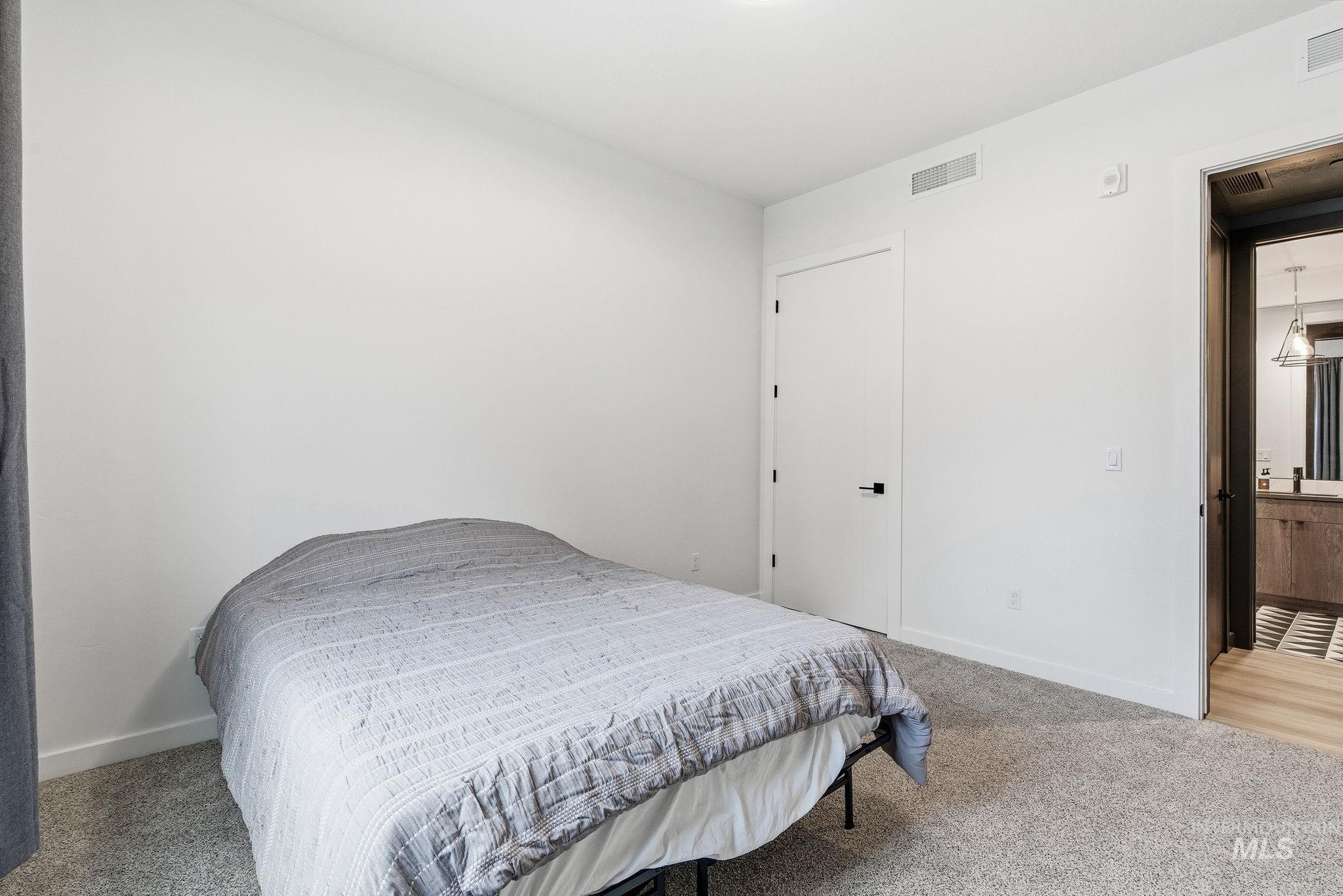 Bedroom featuring light carpet and baseboards