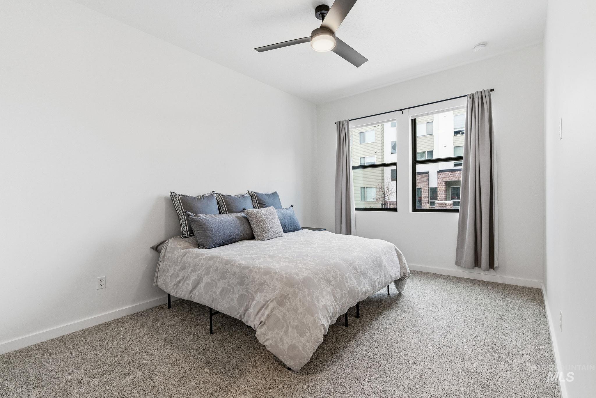 Bedroom with light carpet and a ceiling fan