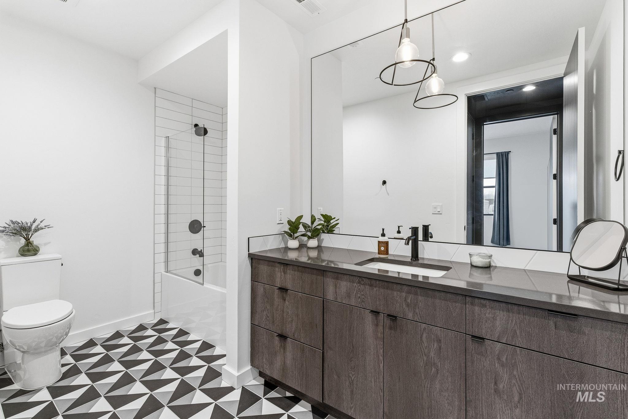 Bathroom featuring vanity, tub / shower combination, light flooring, and recessed lighting