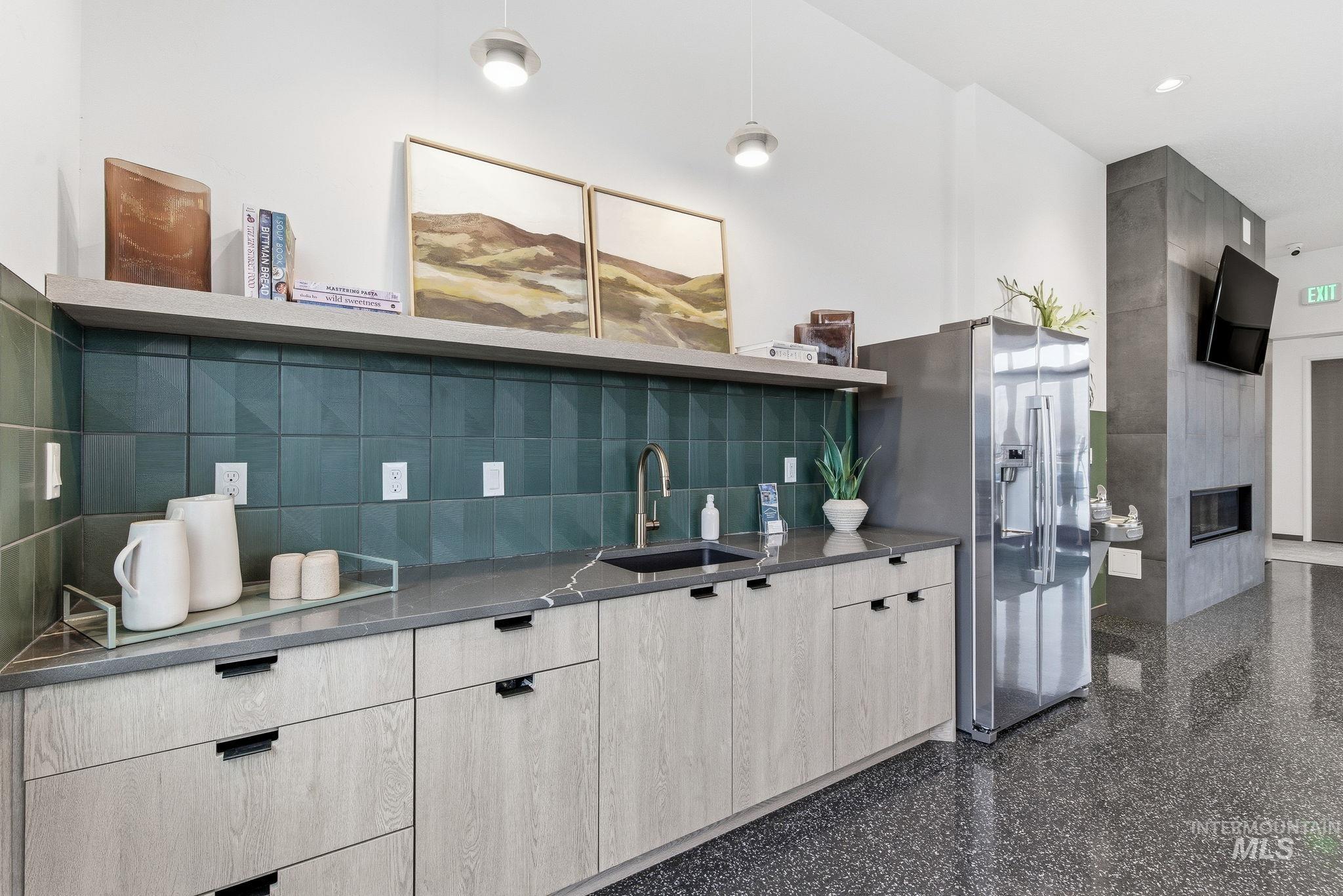 Kitchen featuring open shelves, modern cabinets, stainless steel refrigerator with ice dispenser, dark stone countertops, and a fireplace