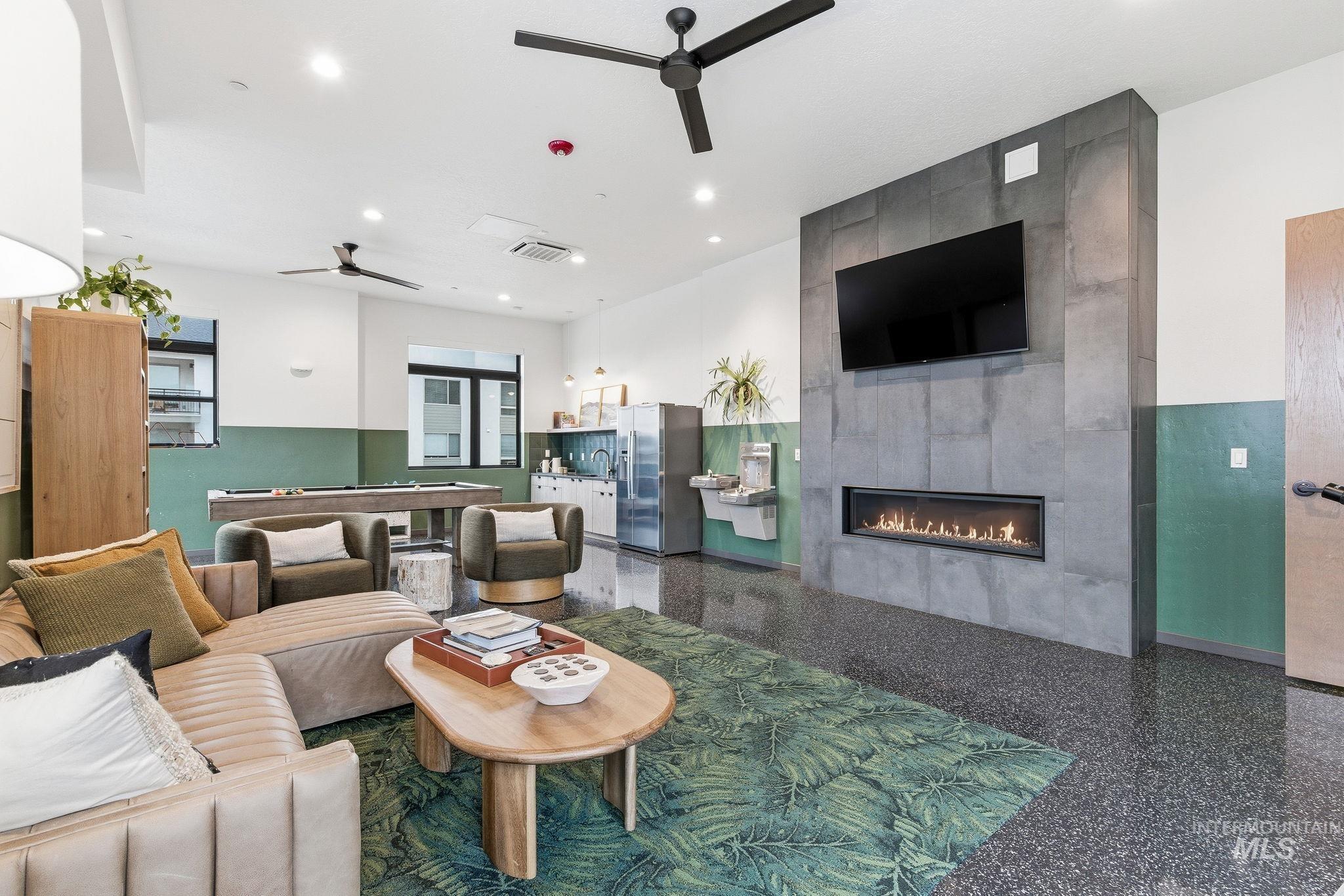 Living room with a ceiling fan, a tile fireplace, speckled floor, recessed lighting, and billiards table