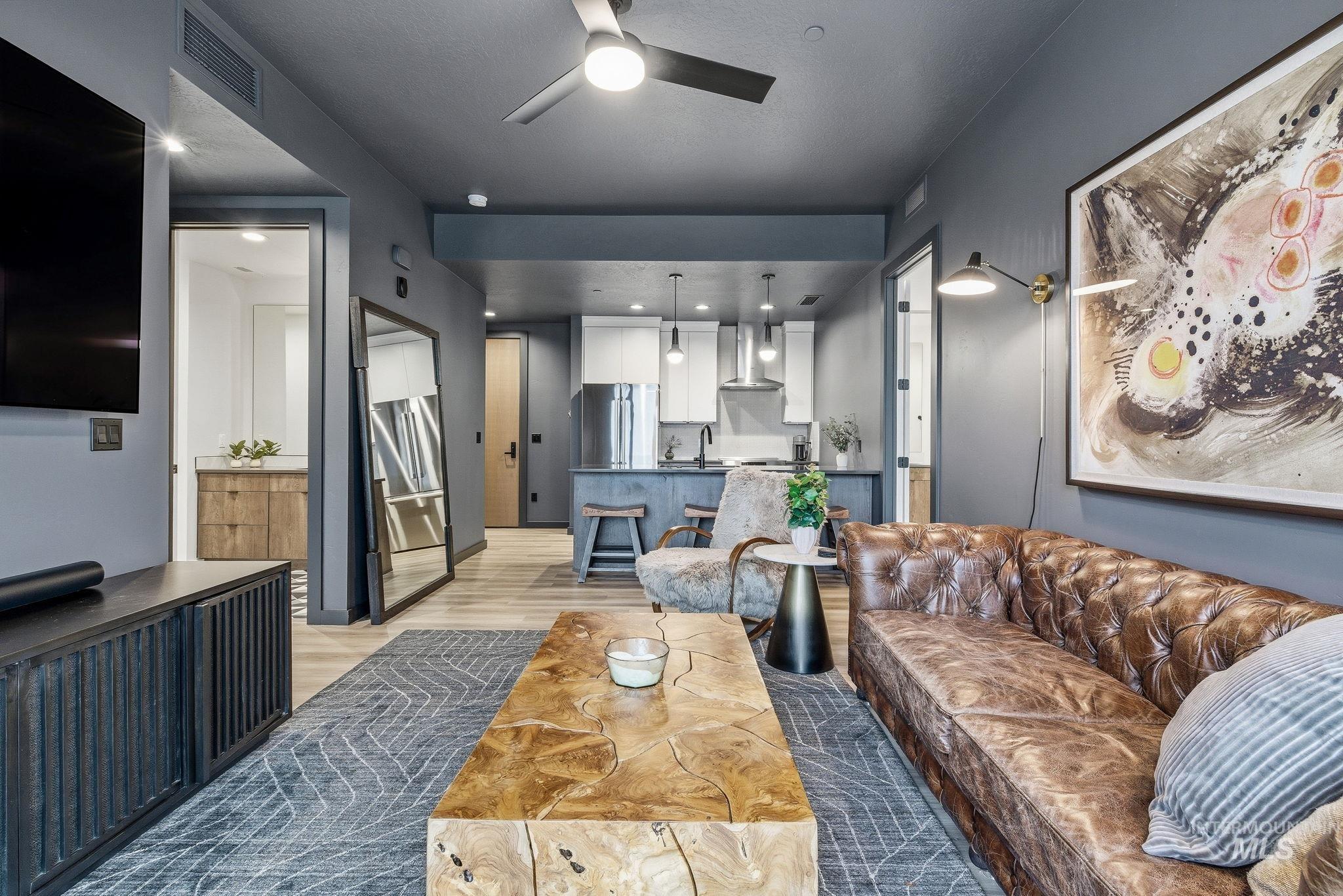 Living room with light wood-type flooring, ceiling fan, and recessed lighting