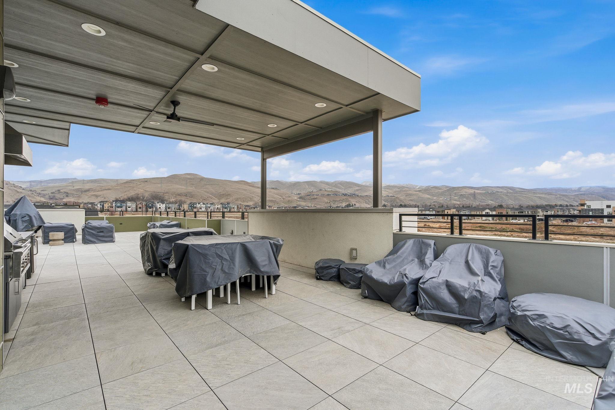 View of patio with a mountain view and area for grilling