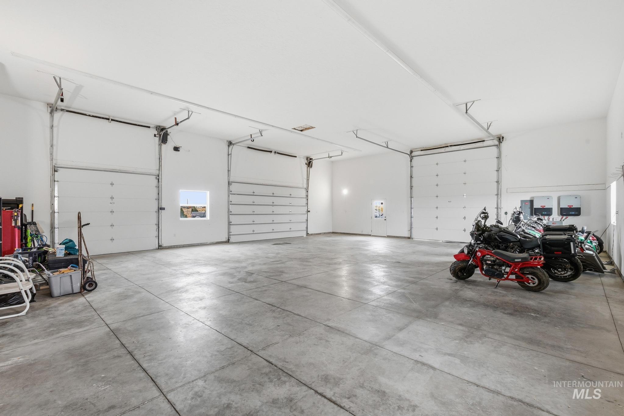 Spacious garage featuring a smooth concrete floor and five overhead garage doors