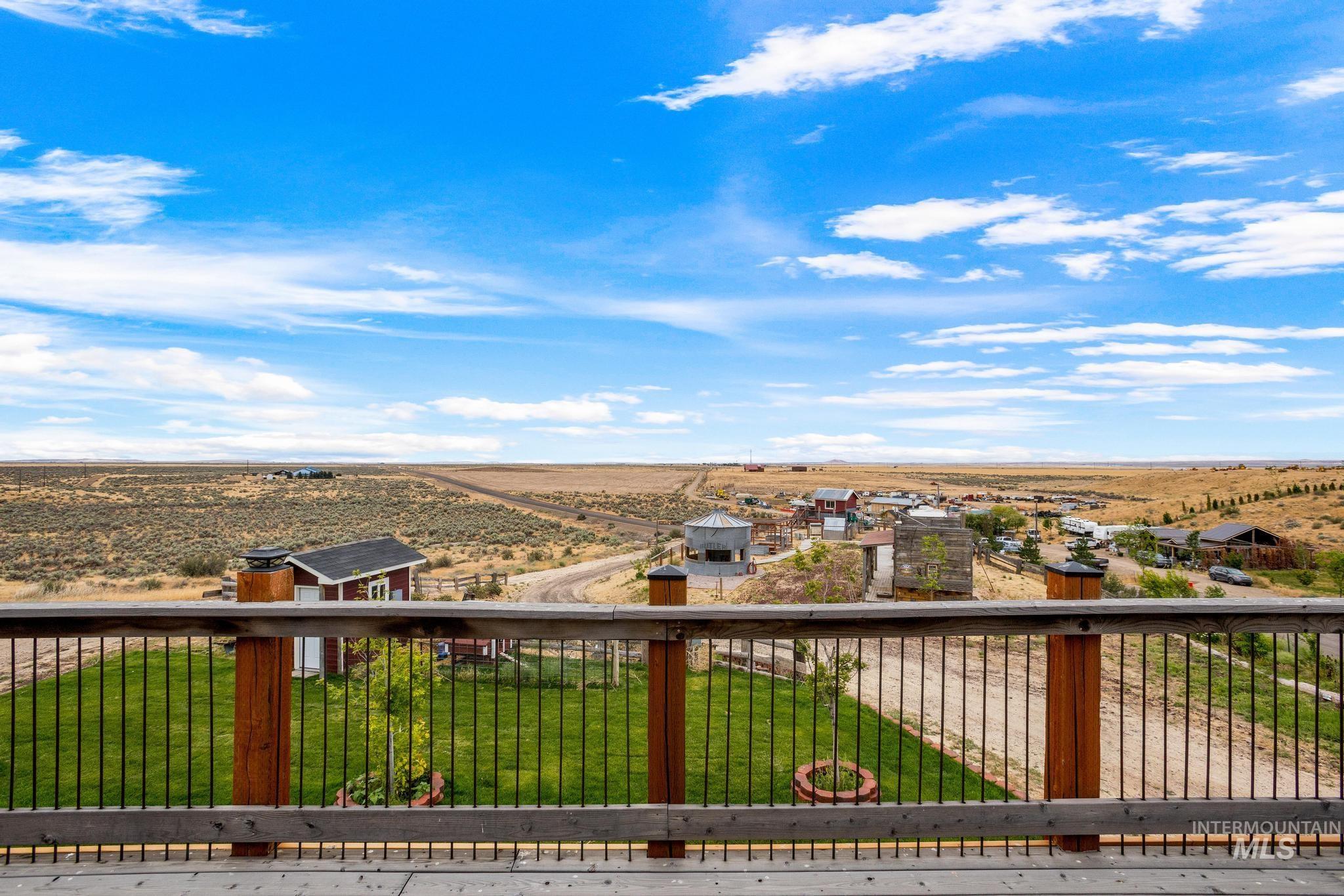 Wood-tone deck with black metal balusters overlooking a vast arid landscape