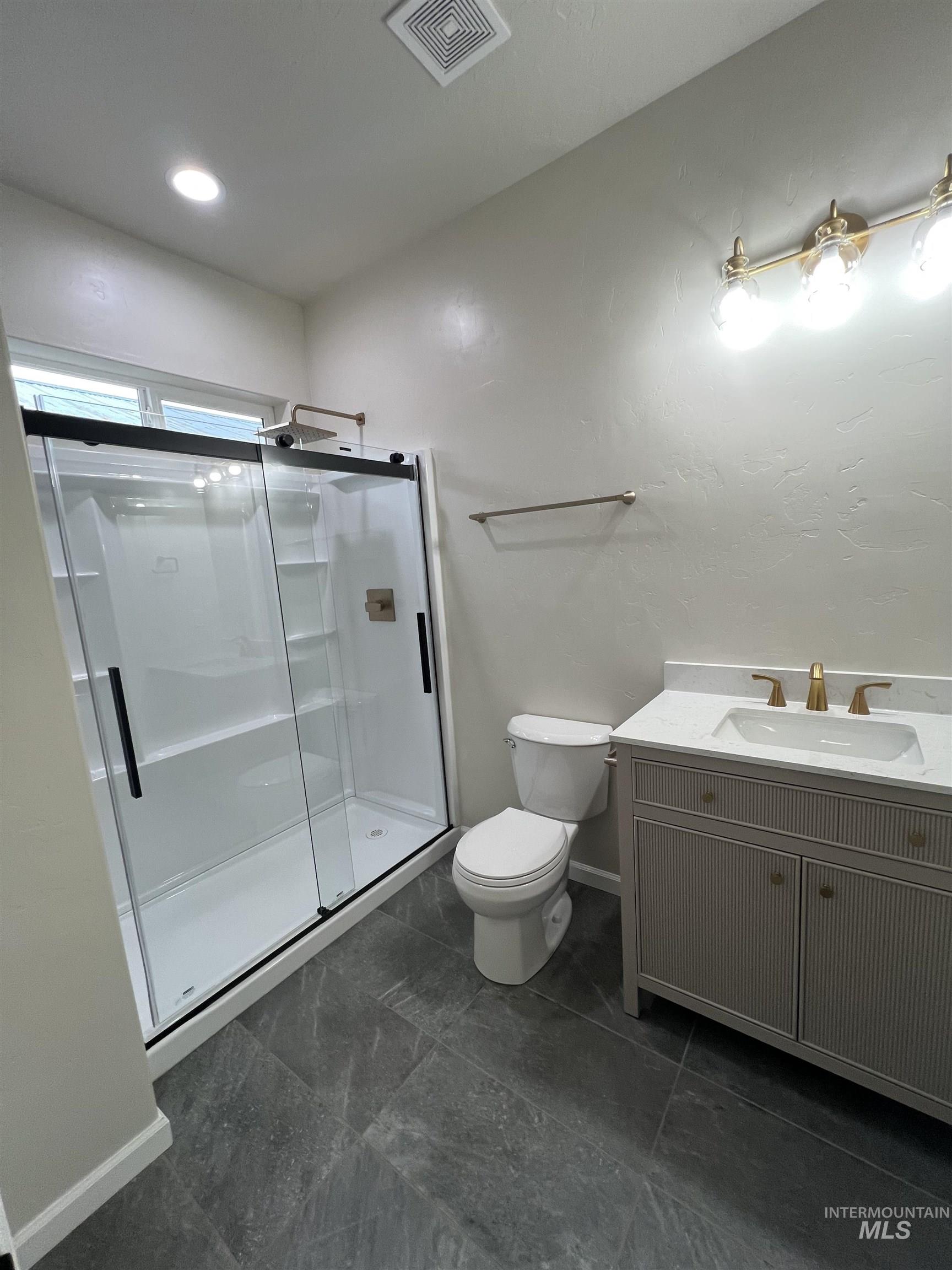Bathroom featuring vanity, a stall shower, and recessed lighting