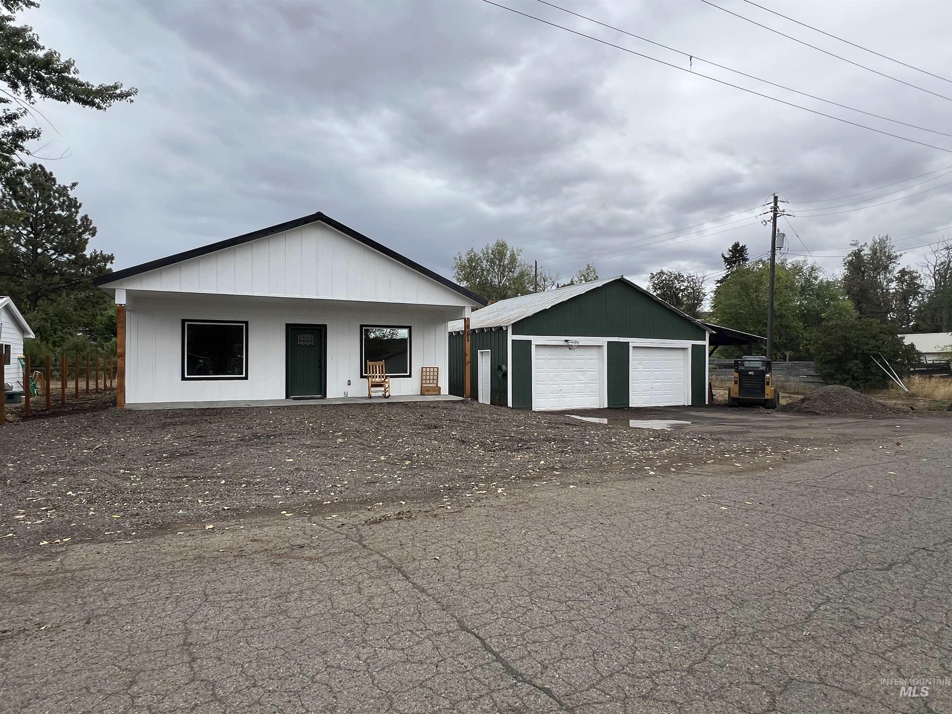 View of front facade with covered porch, a garage, and an outdoor structure