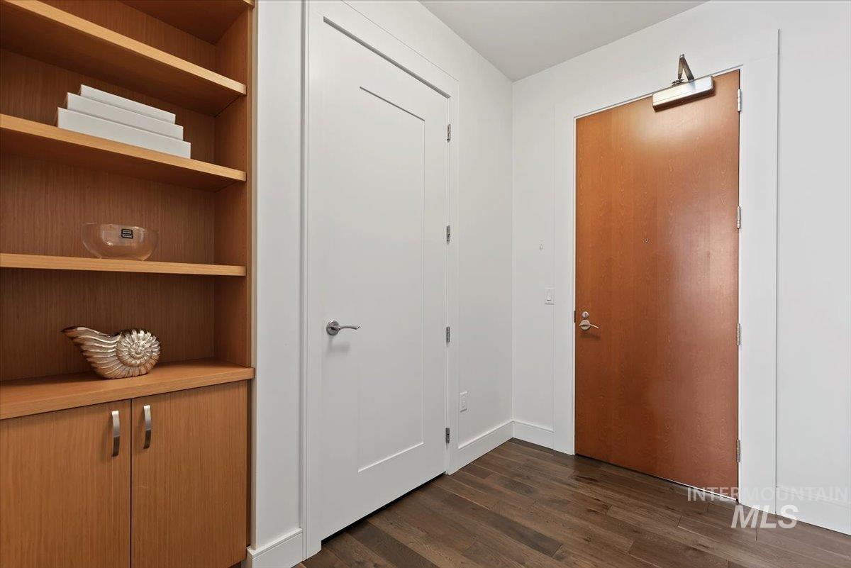 Foyer entrance featuring dark wood finished floors and baseboards