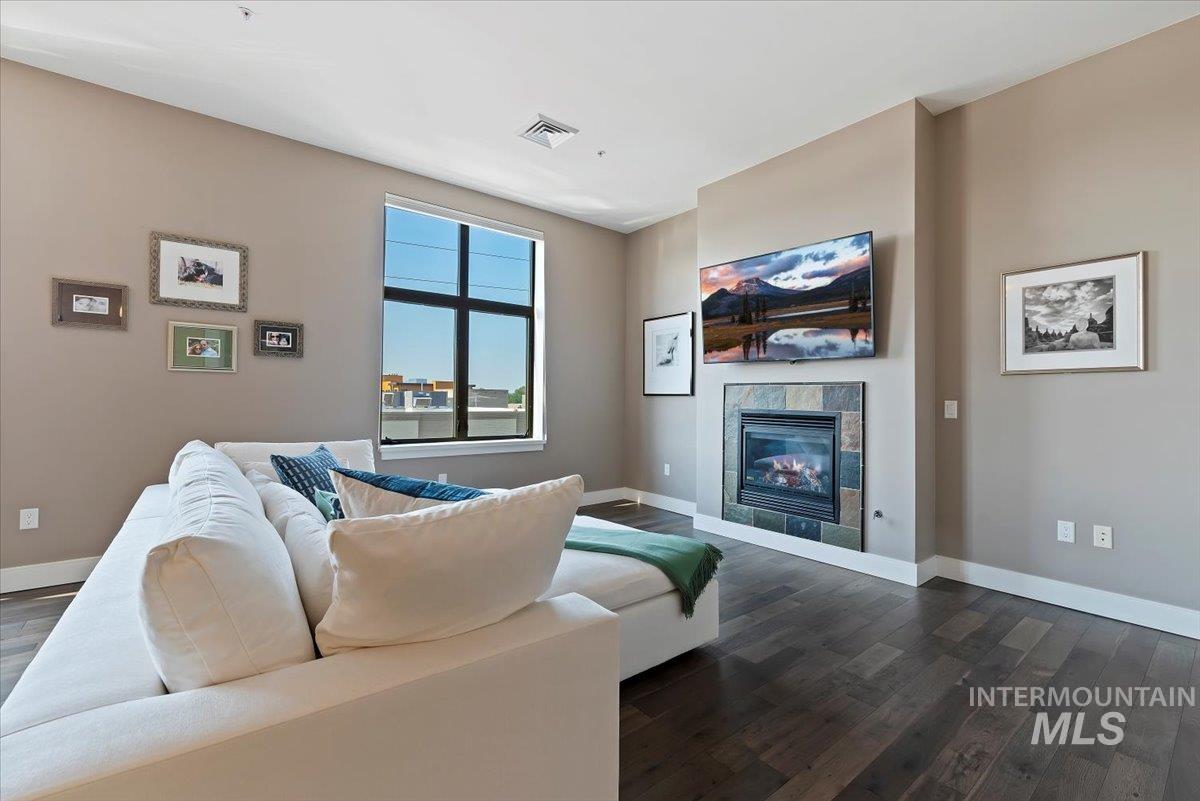 Living area featuring dark wood-type flooring and a tile fireplace